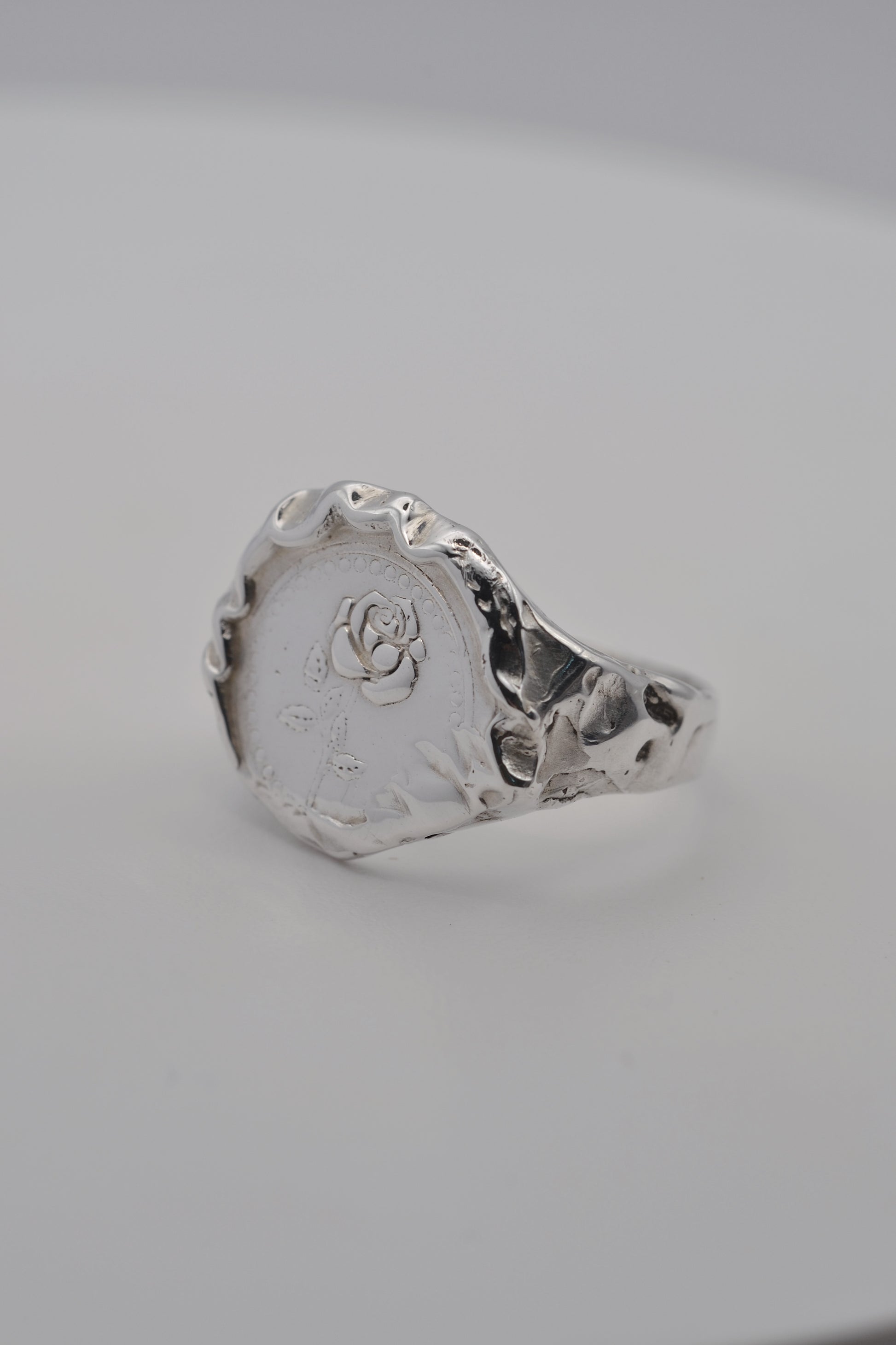Side view of a handmade molten silver signet ring, showcasing organic textures formed through the lost wax jewellery making process.