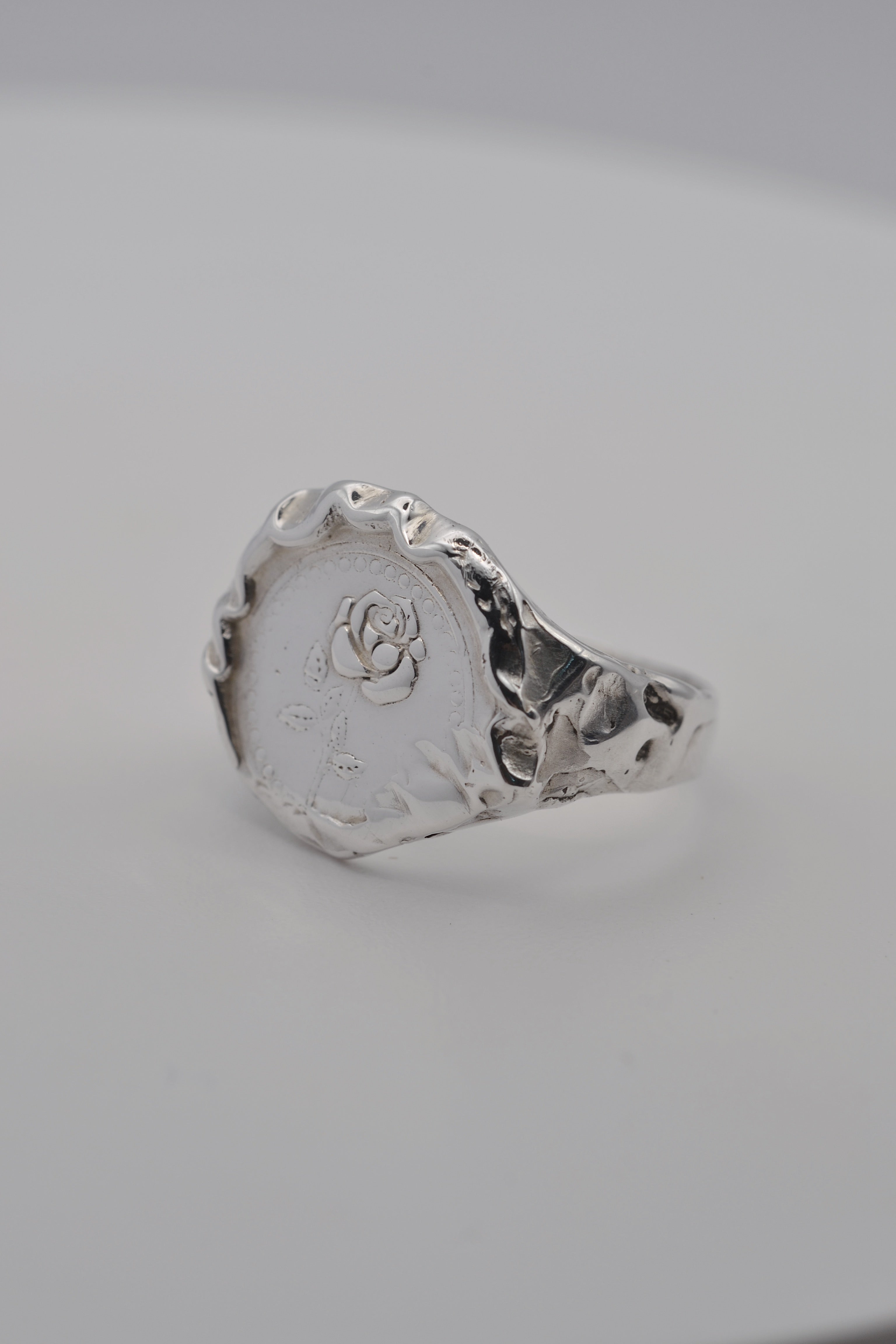 Side view of a handmade molten silver signet ring, showcasing organic textures formed through the lost wax jewellery making process.