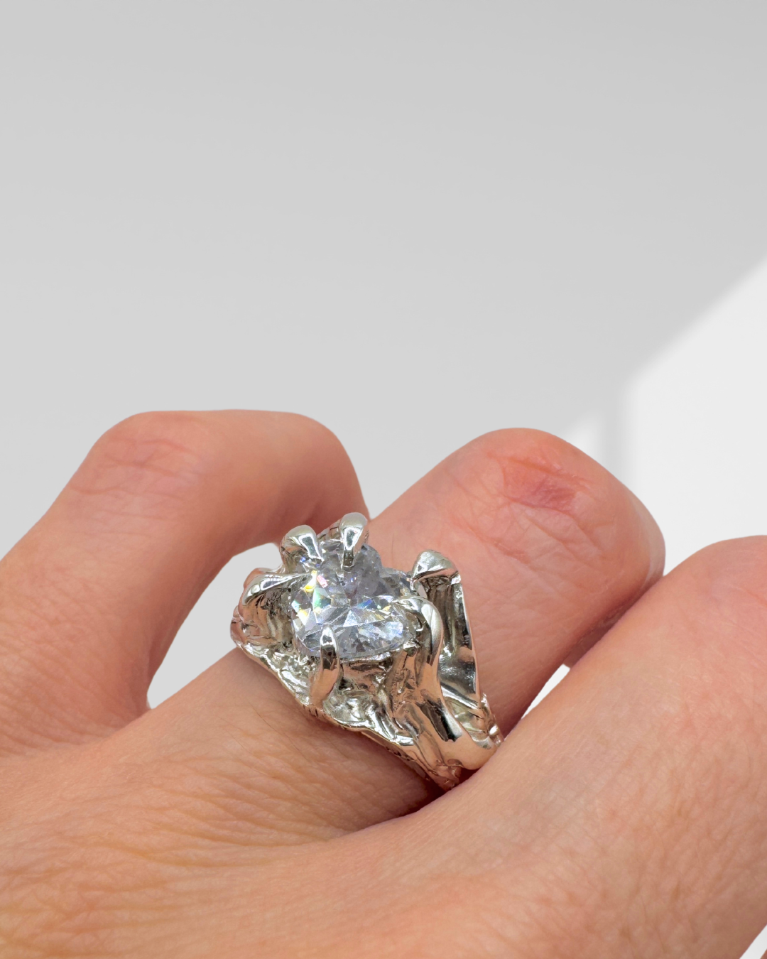 Organic gothic heart ring made from sterling silver, featuring 6 claw prongs, molten texture, and a clear cubic zirconia—crafted by hand with lost wax.