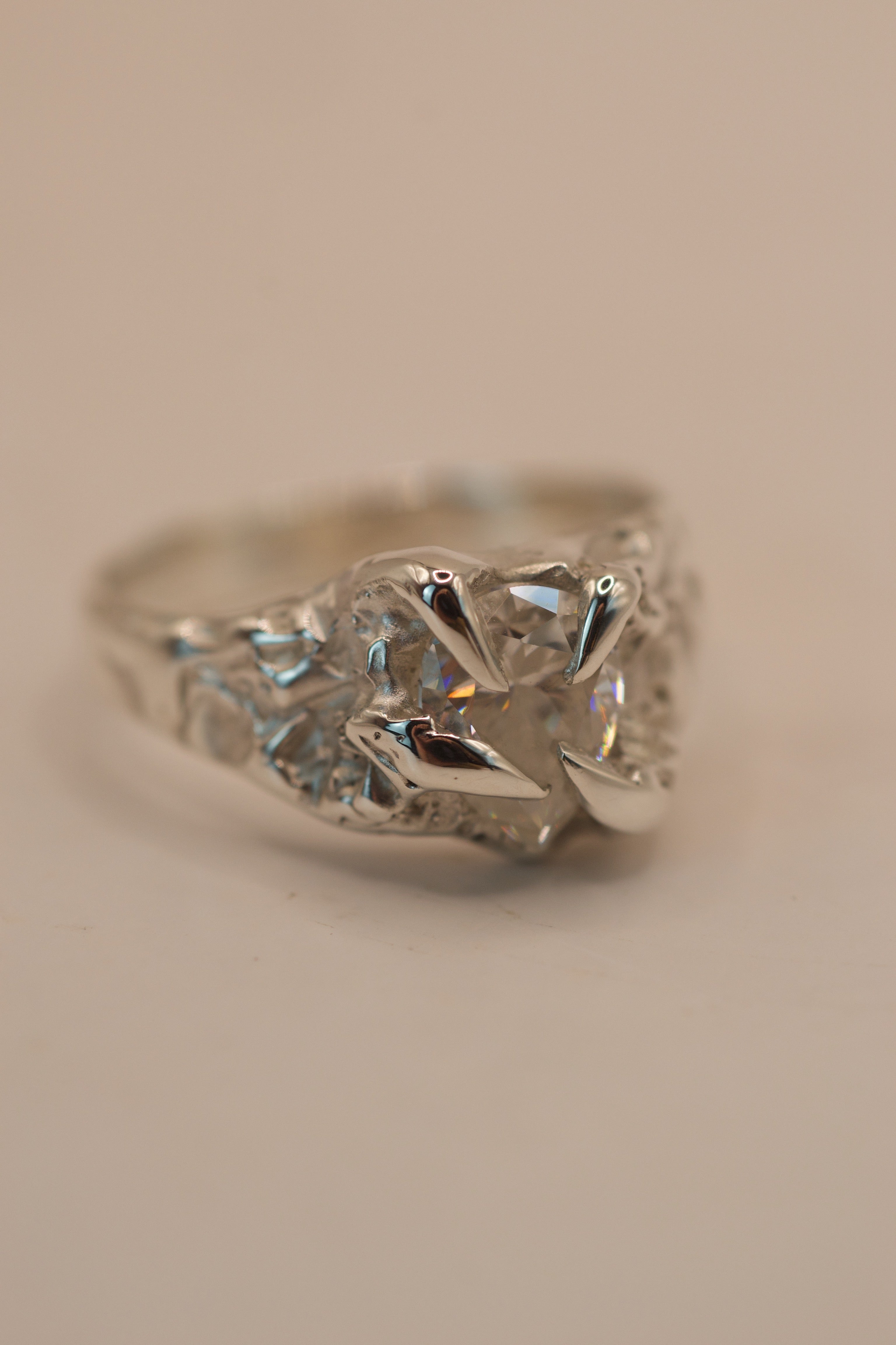 Alternative engagement ring featuring a pear cut moissanite in sterling silver, handmade with the lost wax method and gothic inspired claw setting.