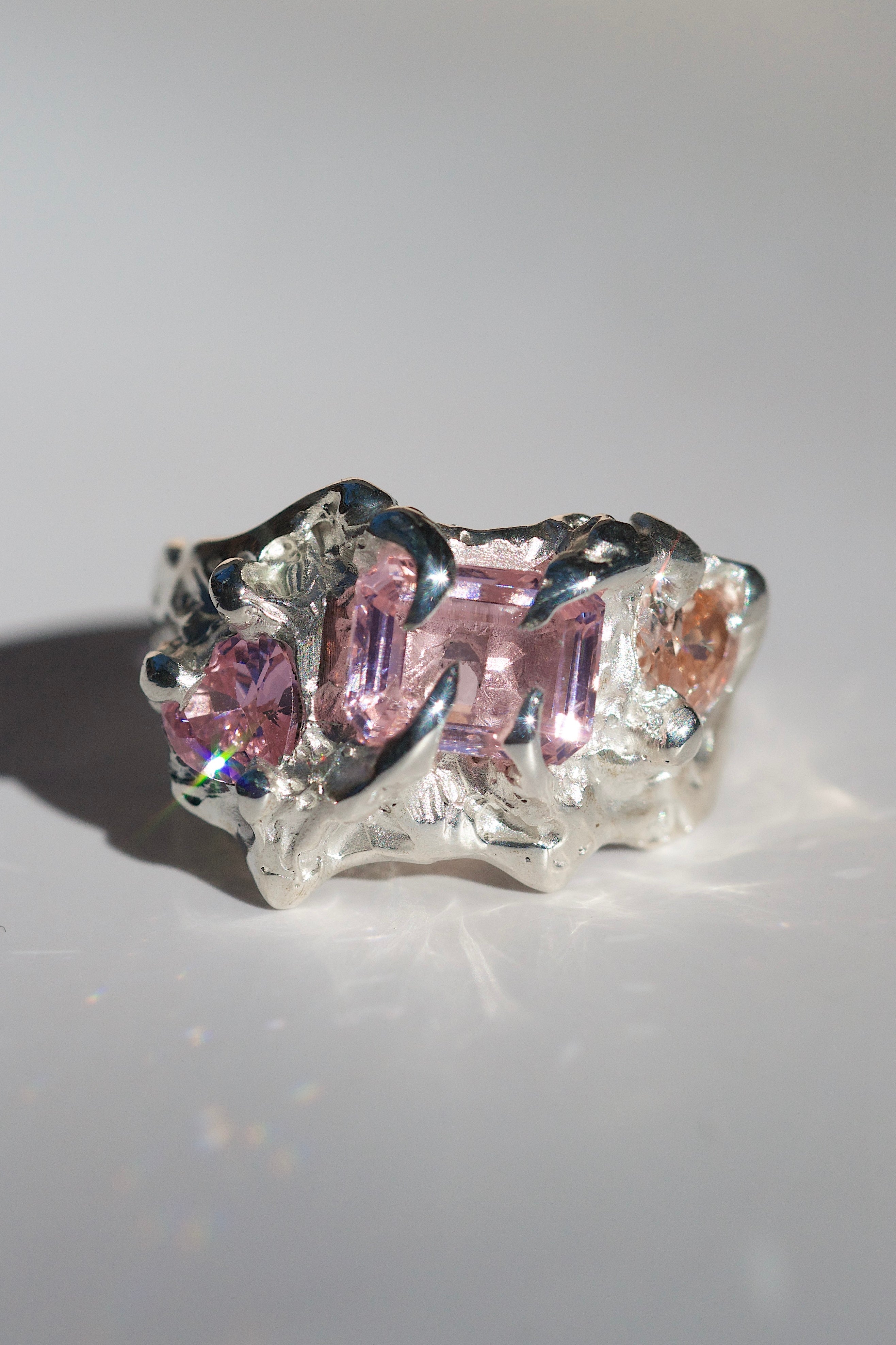 Organic silver heavily textured fantasy ring with pink gemstones, champagne heart stones and molten silver front facing