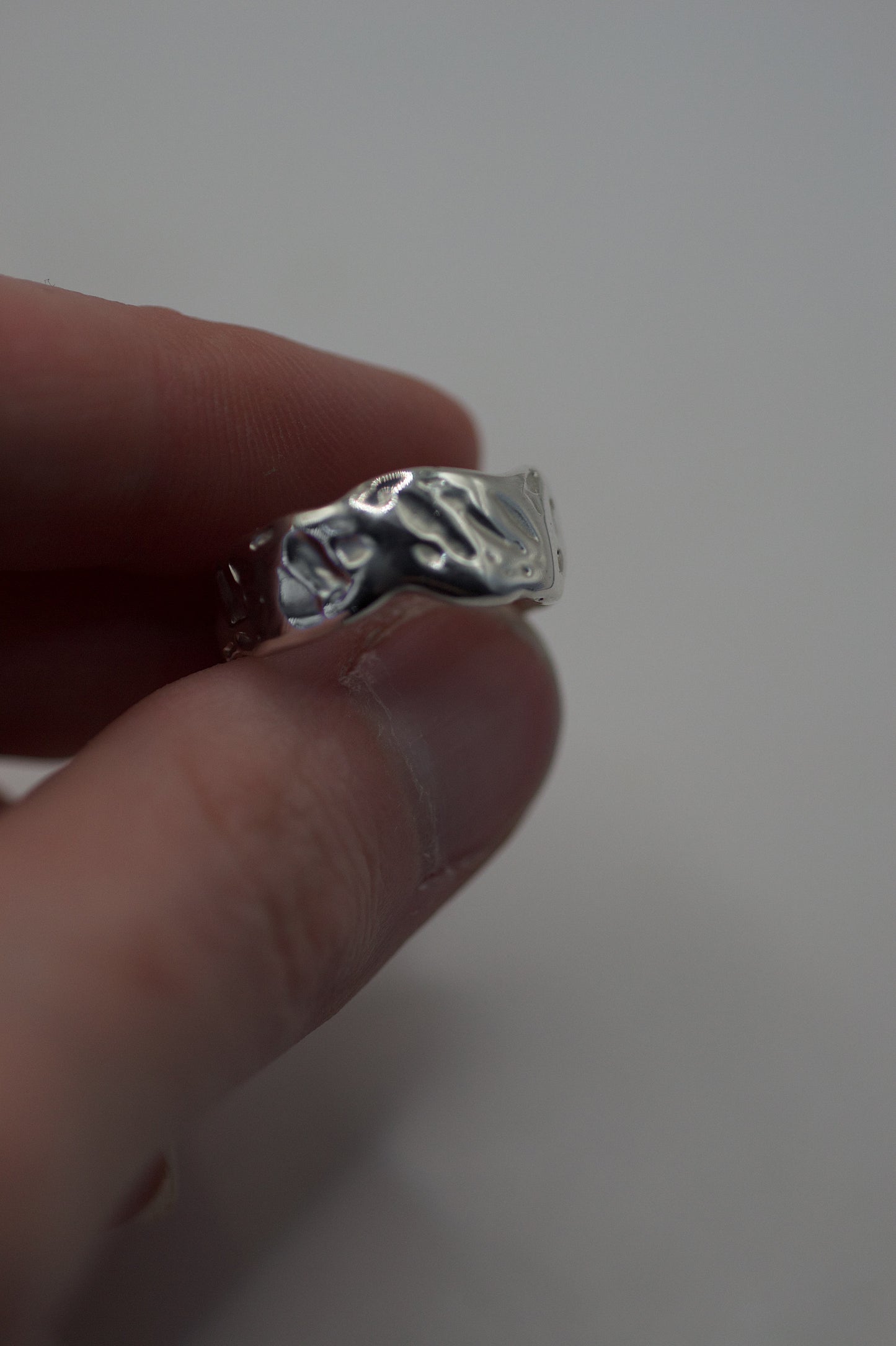 Side profile of lost wax cast silver ring showing textured edge and sculptural hand-formed surface