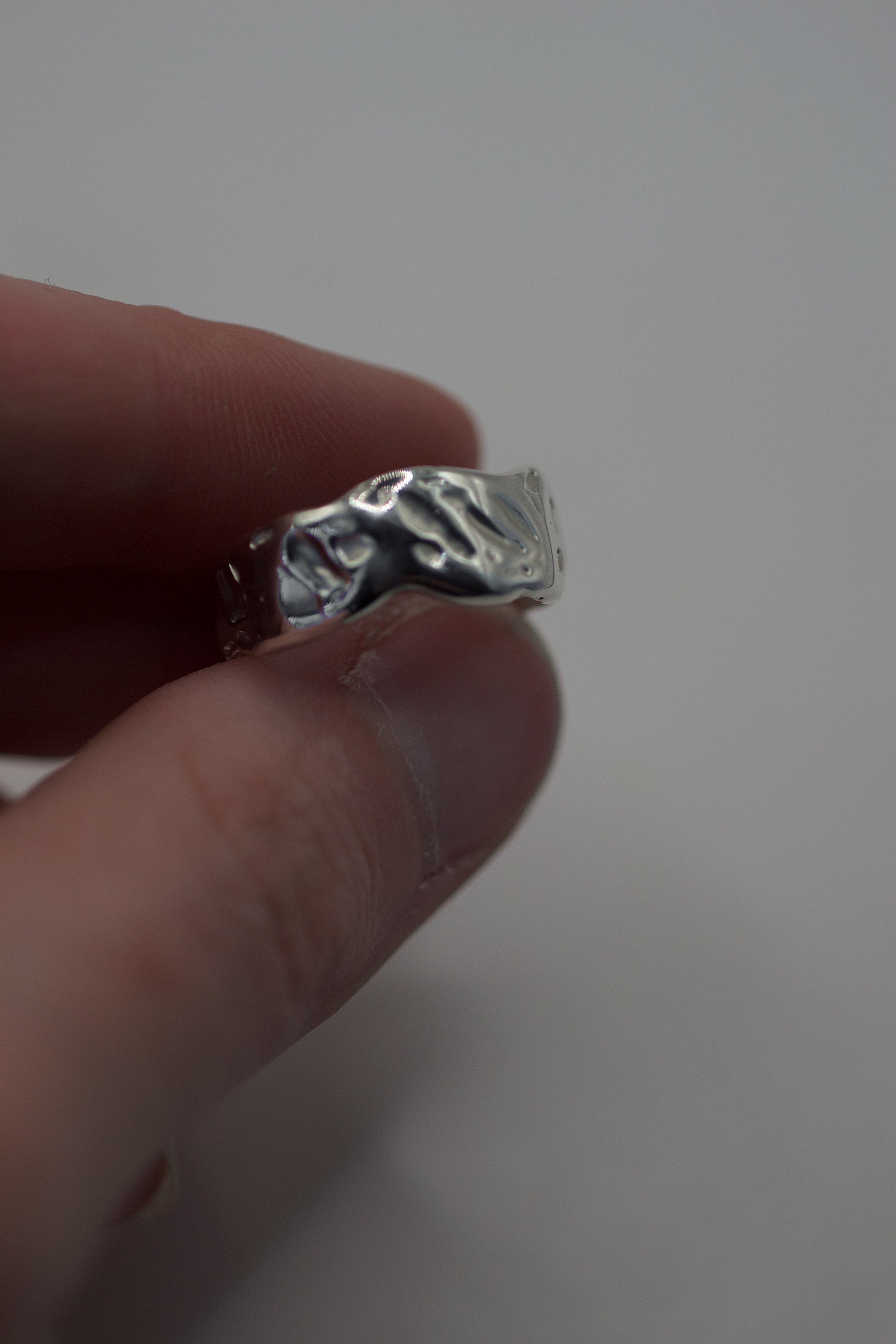 Side profile of lost wax cast silver ring showing textured edge and sculptural hand-formed surface