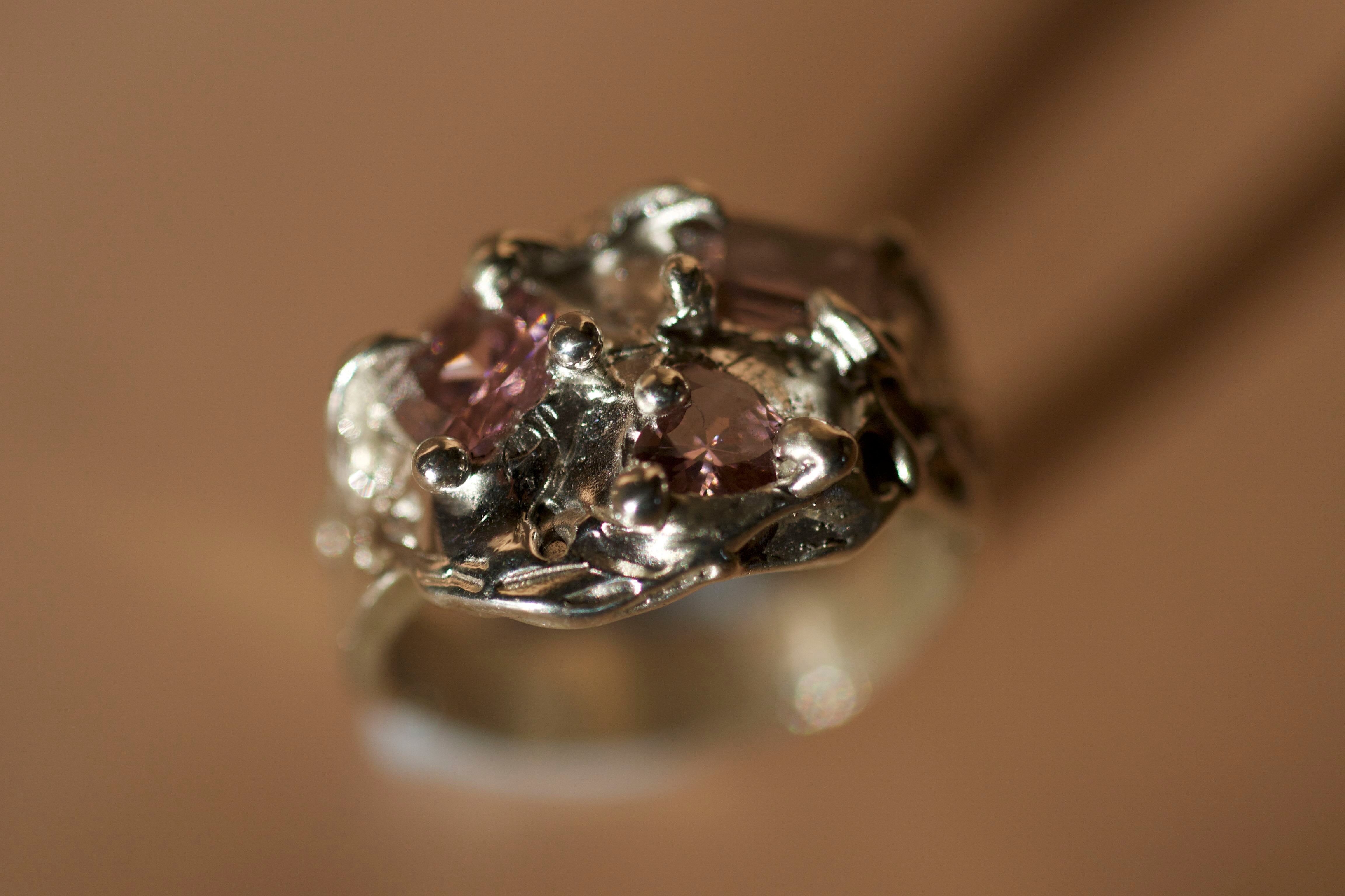 Highly detailed with molten texture and bubbles and curves. Molten silver cluster ring with claws and melting look. Three light pink crystals - heart, square and cushion shaped. Thick tip section of the ring. Organic textured & Y2K aesthetic jewellery.