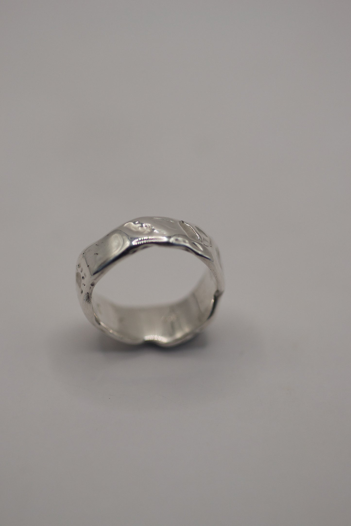 Handcrafted silver ring with organic uneven form and molten style texture from wax sculpting