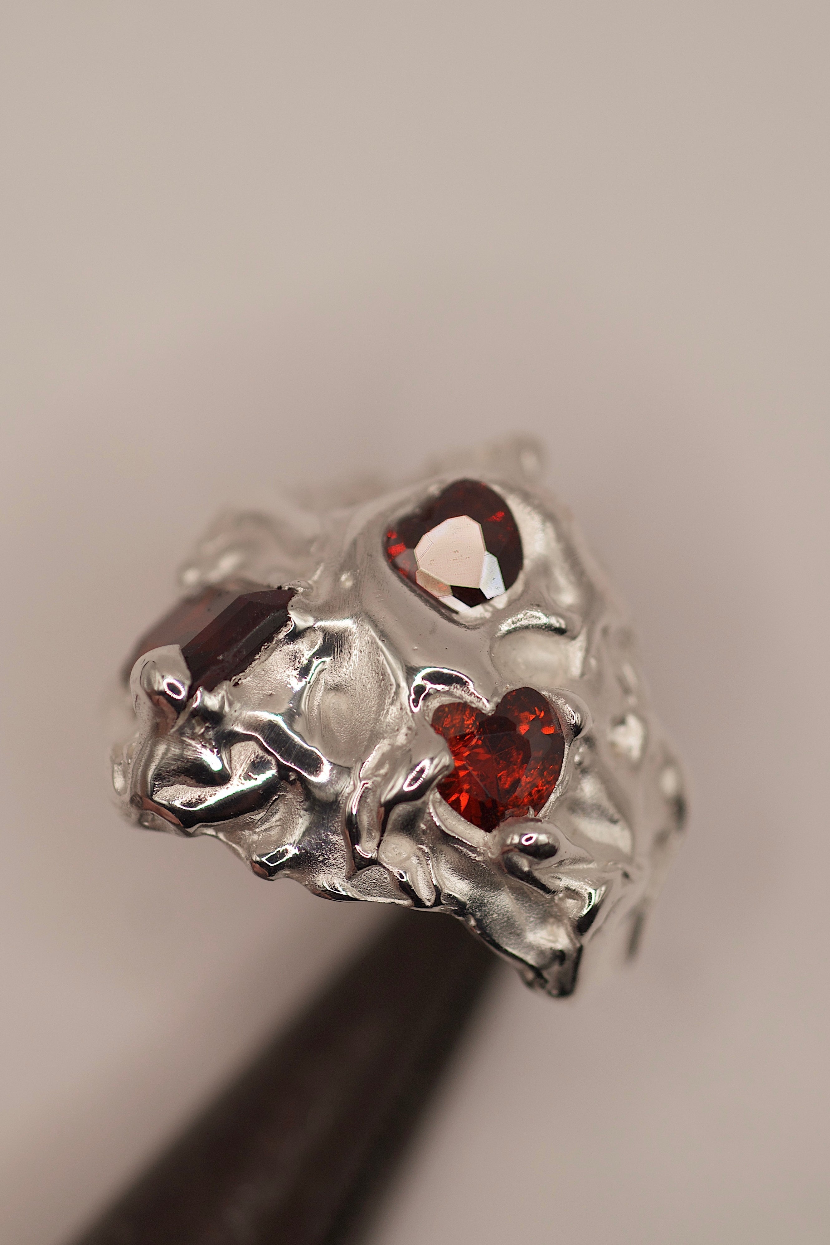 Bold sculptural alternative jewellery Amour Ring lost wax cast in sterling silver with red garnet and heart cubic zirconia statement piece