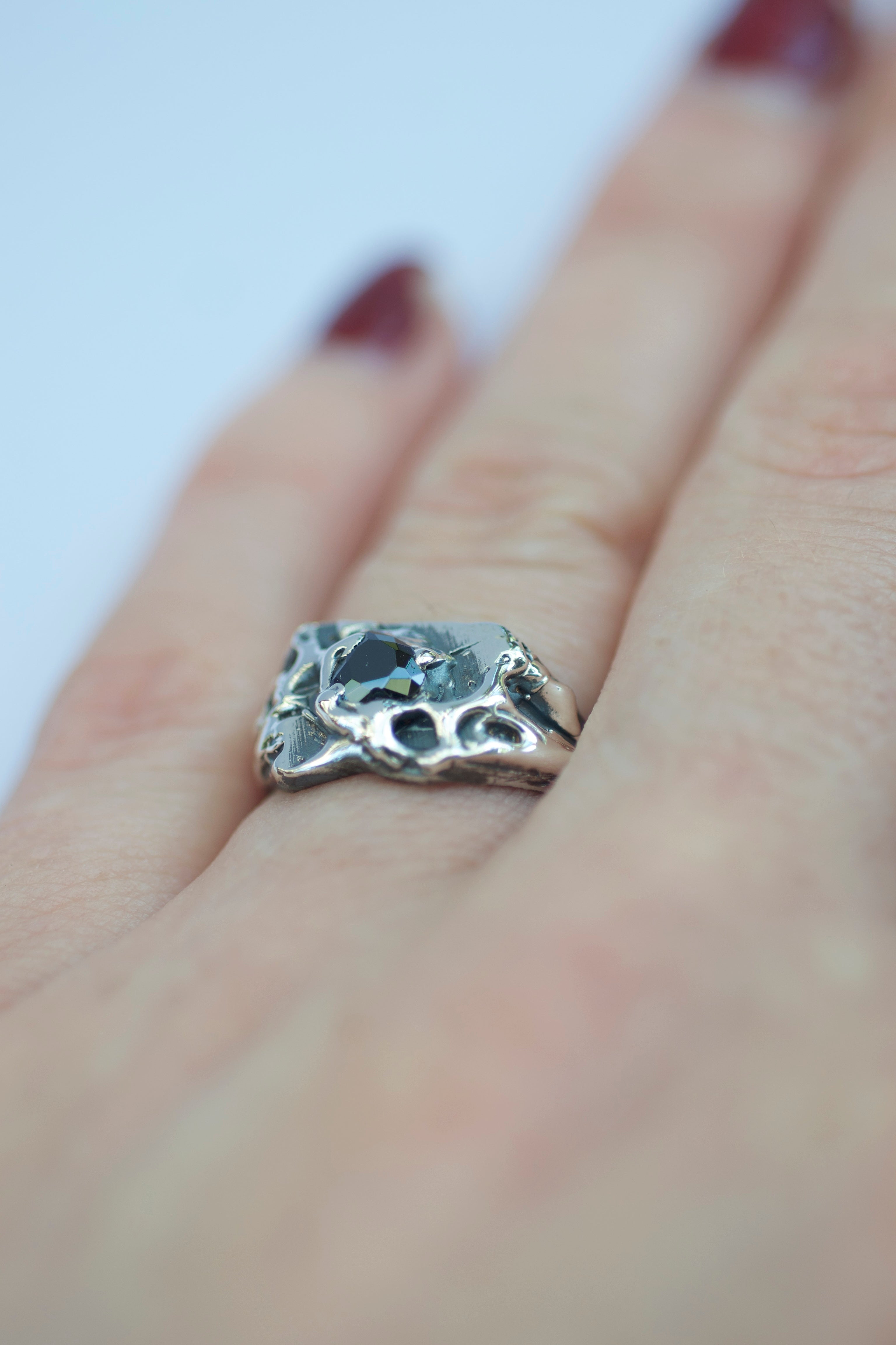 Lost wax cast silver Beloved Ring worn on hand with black heart cubic zirconia and organic molten silver setting gothic inspired alternative jewellery