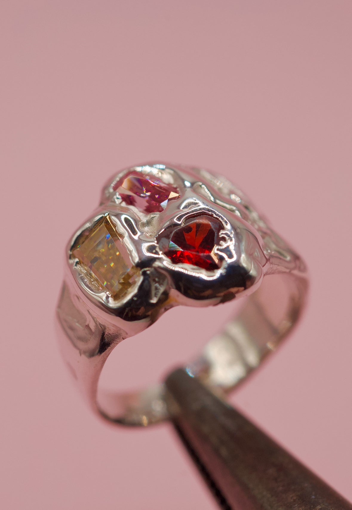 Handmade lost wax cast sterling silver ring with molten silver melted around candy-coloured moissanite and cubic zirconia stones, playful sculptural ring made using the wax carving technique