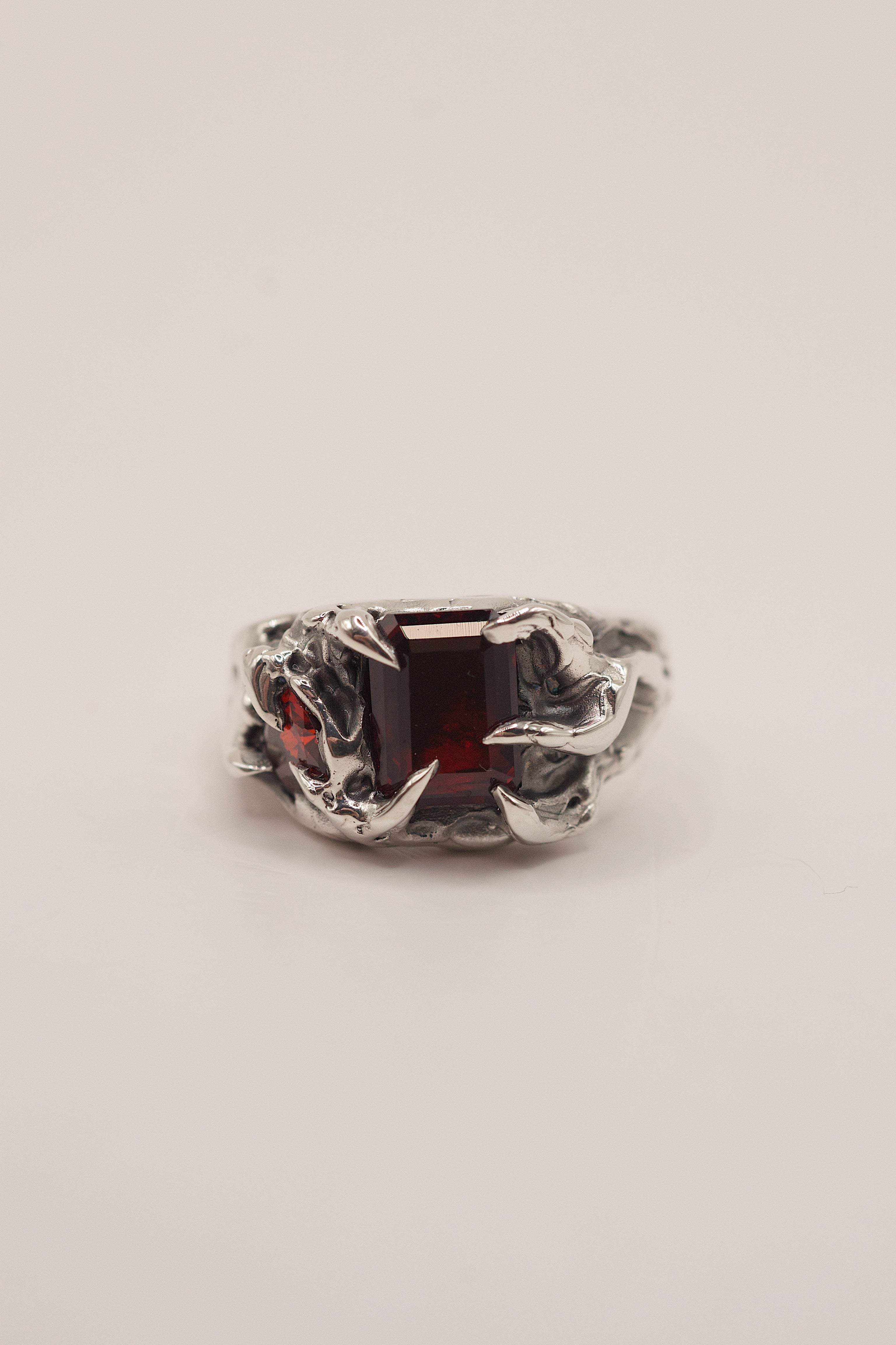 Cherry Ring in black ring box showing red lab-grown garnet and sharp organic sterling silver claws handmade using the lost wax casting technique