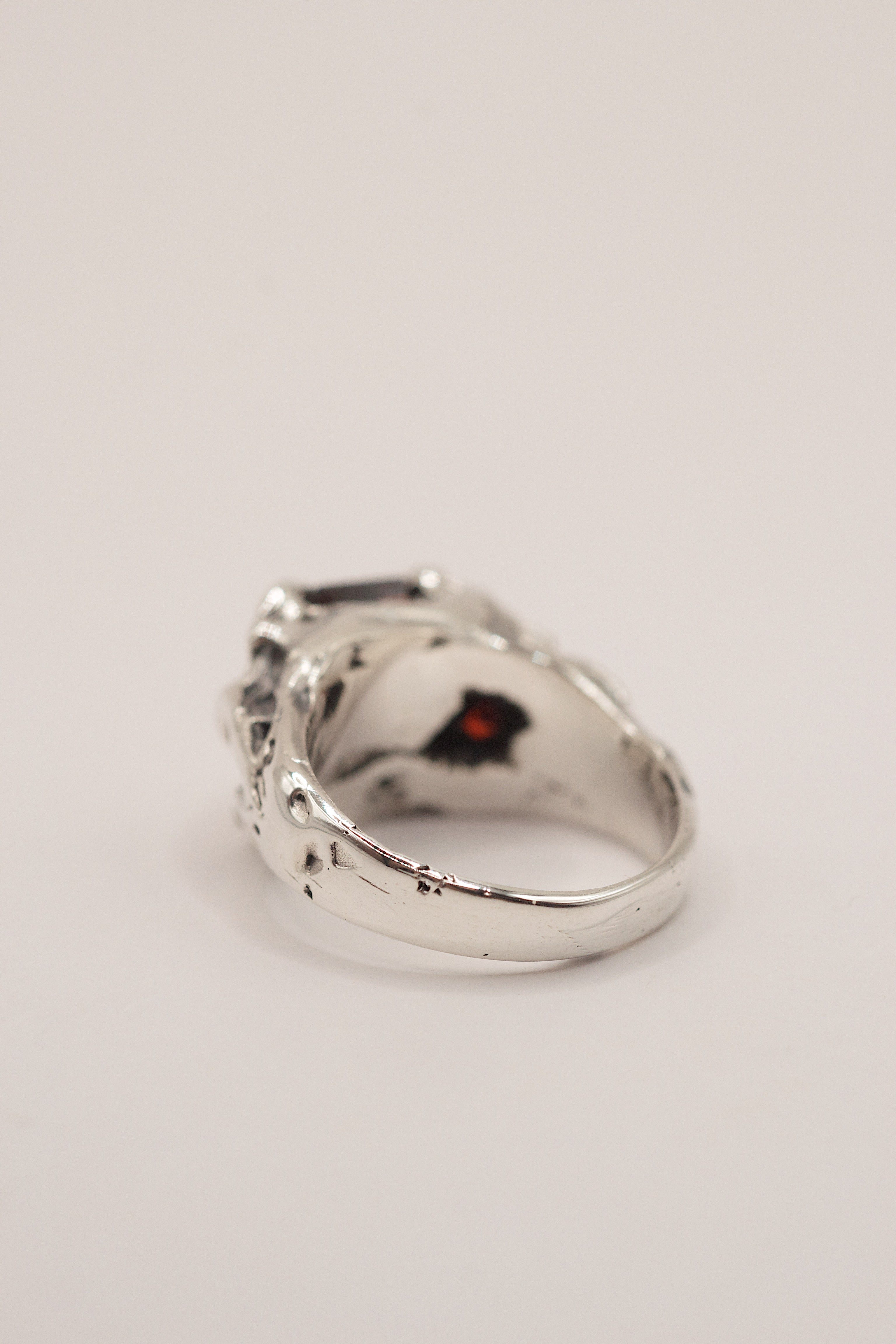 Side angle of the Cherry Ring showing organic recycled sterling silver band with sharp claw and red garnet detail handmade using lost wax casting