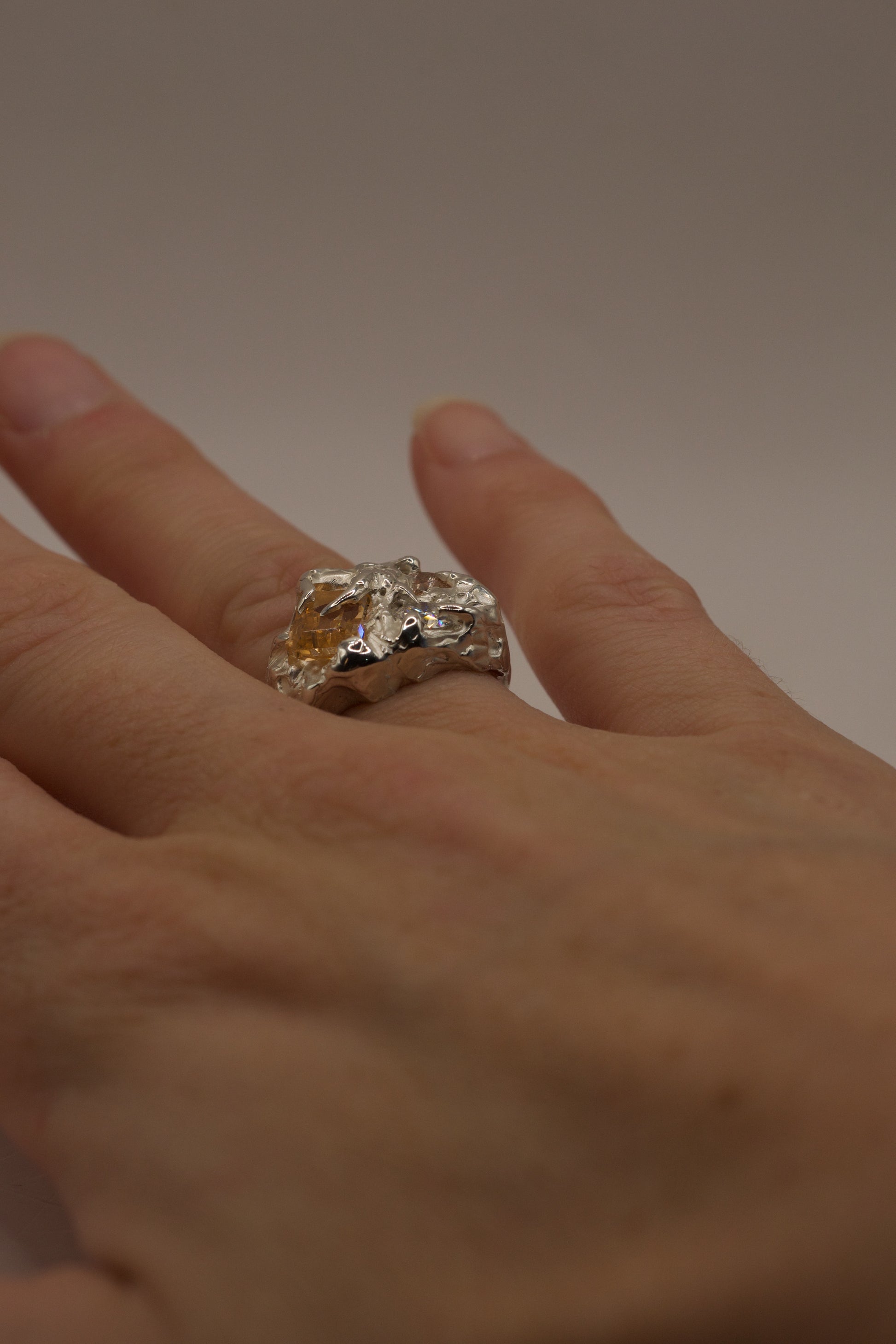 Handmade chunky organic silver ring on fingers.