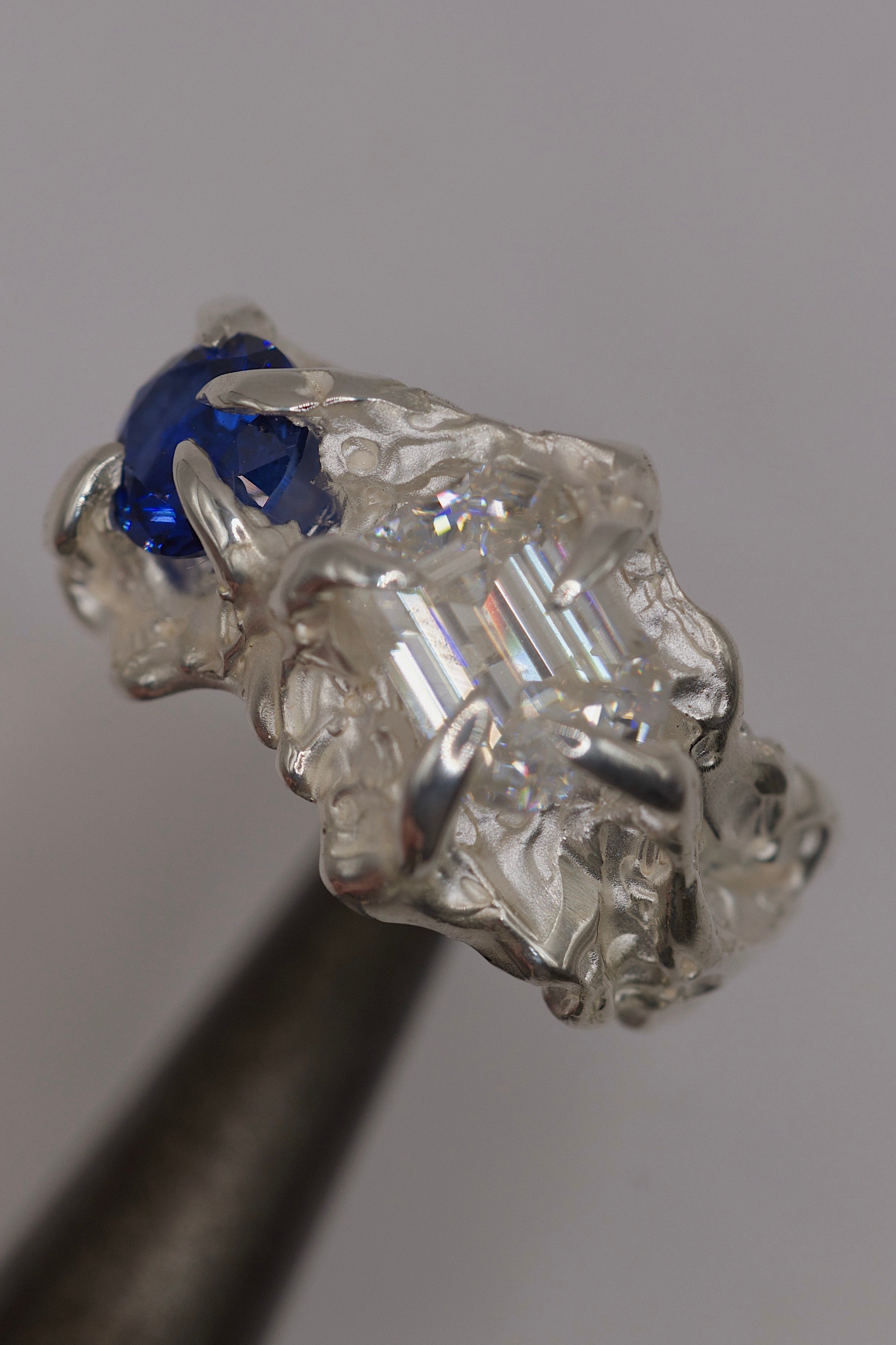 Close up shot of sterling silver ring with heavy textures and pliers.