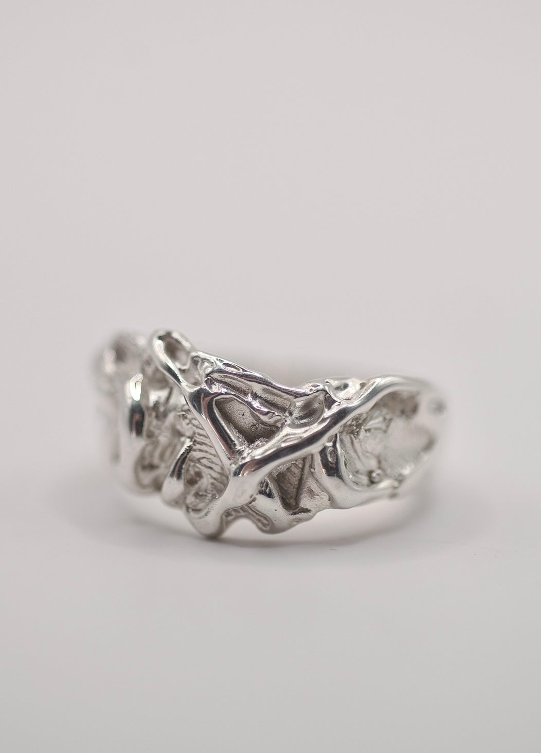 Handmade lost wax cast sterling silver ring with layered organic molten texture like frosting, playful alternative ring made using the wax carving technique