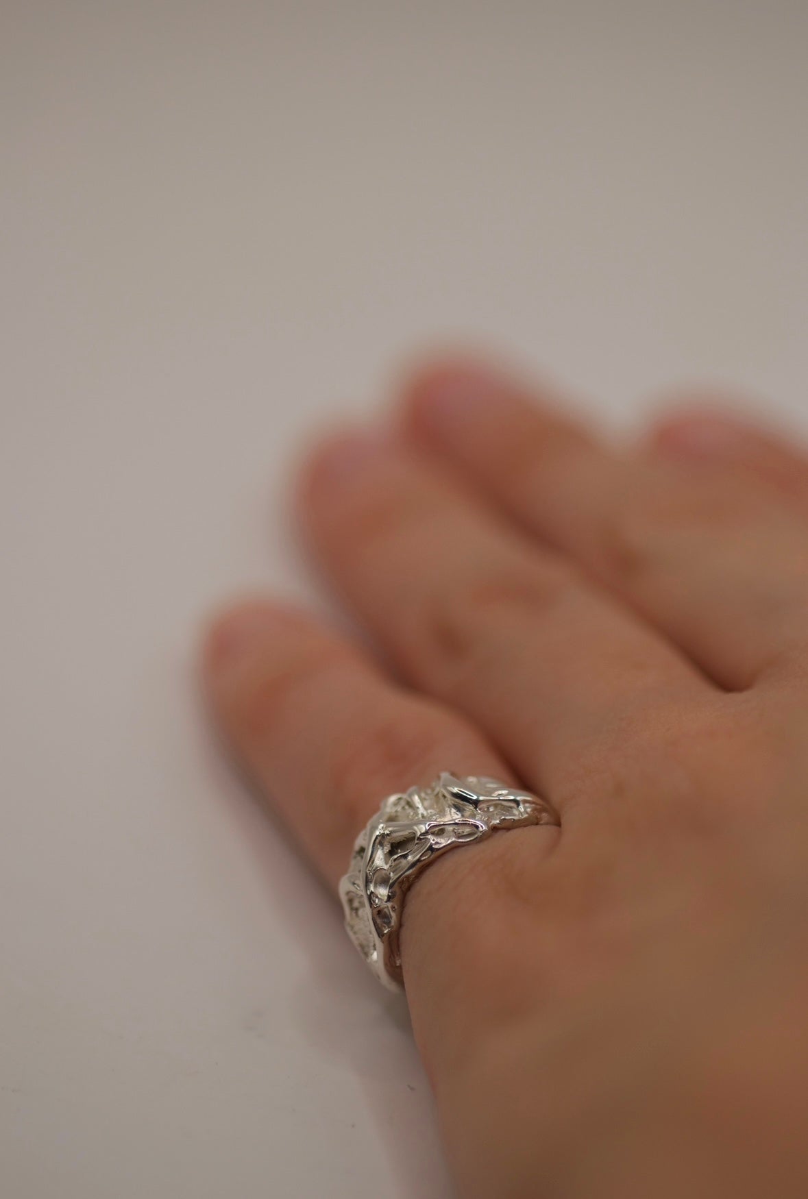 Lost wax cast silver Cream Ring worn on hand with layered organic molten sterling silver texture handmade using the wax carving technique