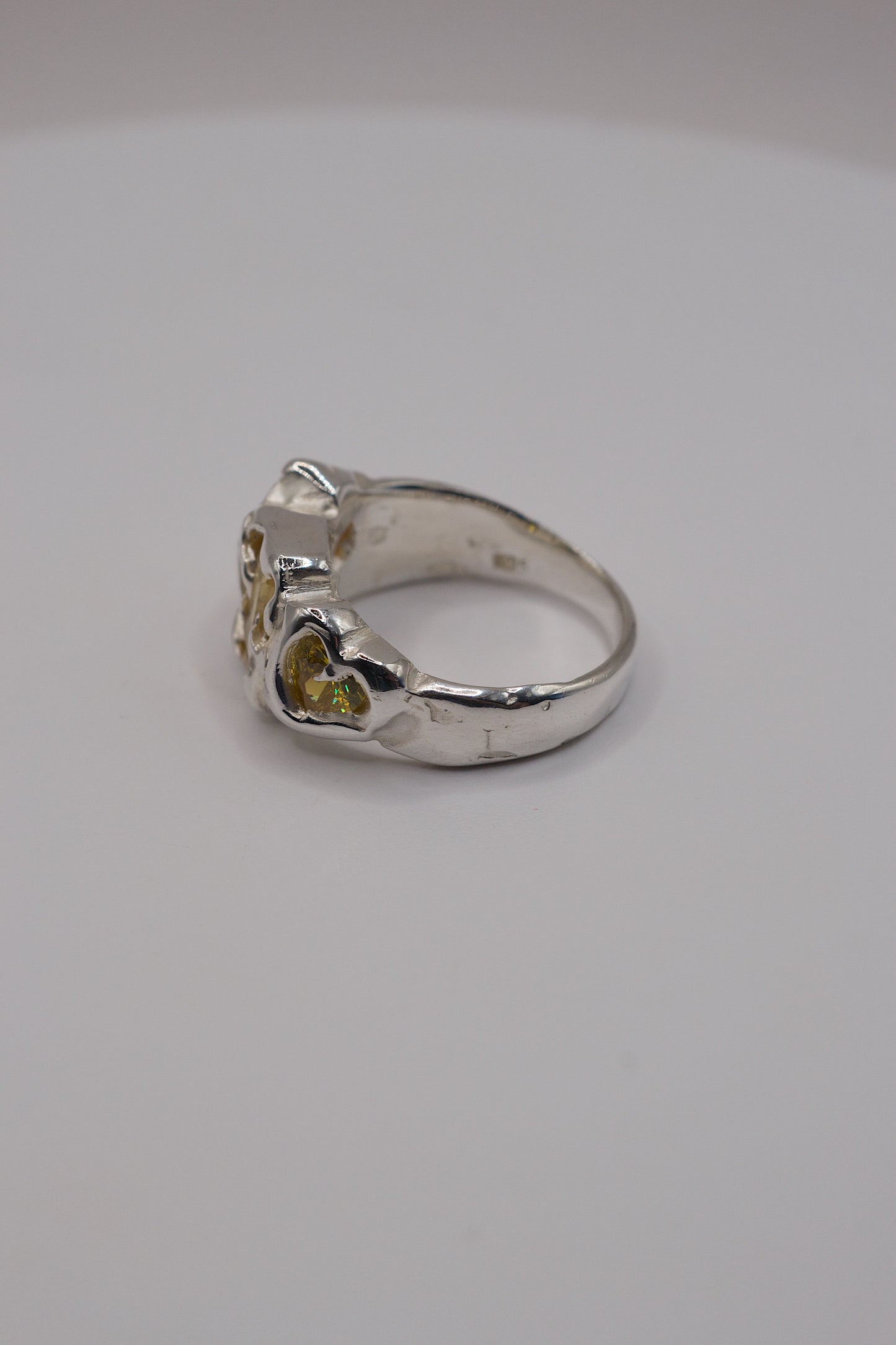 Sterling silver ring side view with molten textures and yellow heart cubic zirconia.