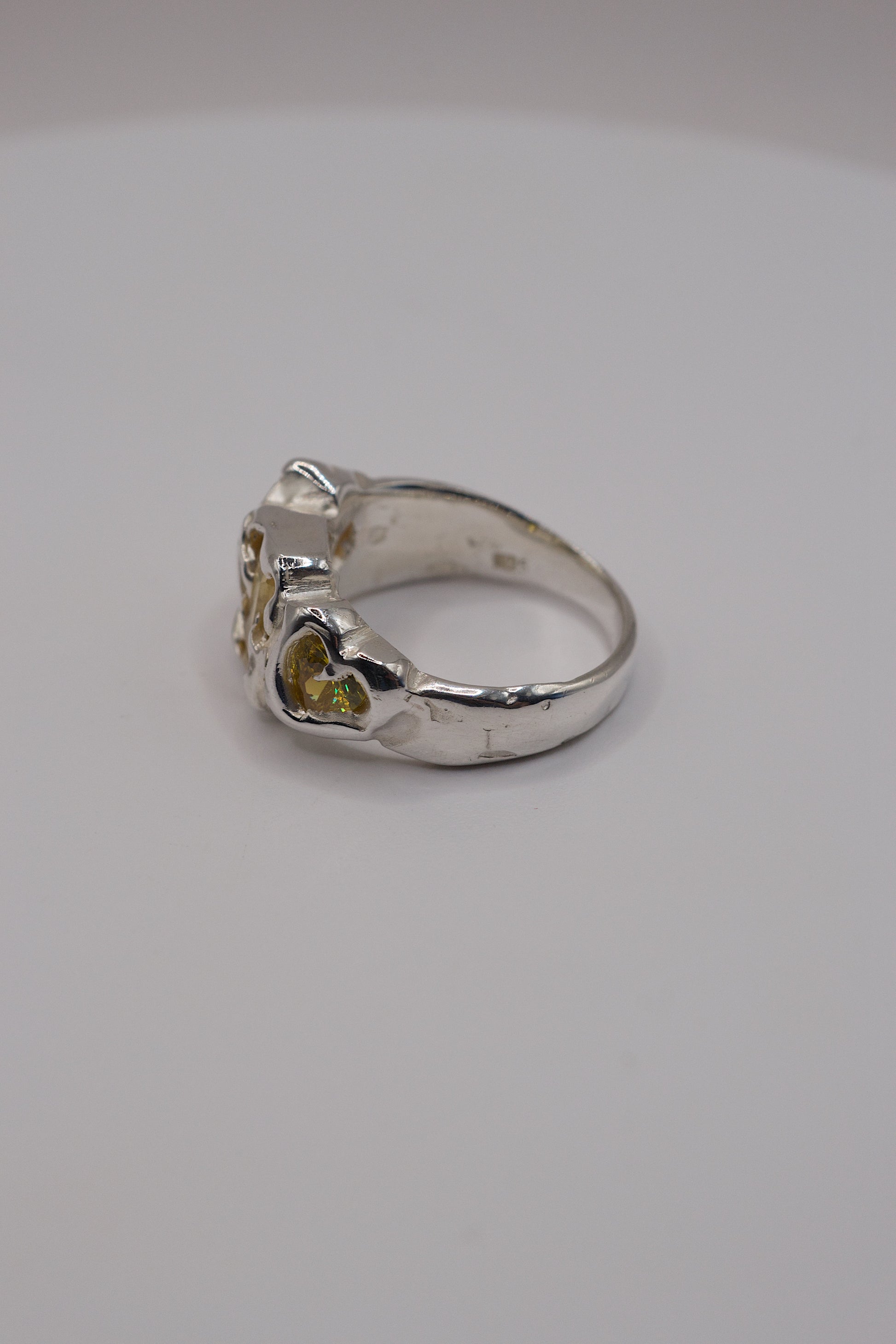 Sterling silver ring side view with molten textures and yellow heart cubic zirconia.