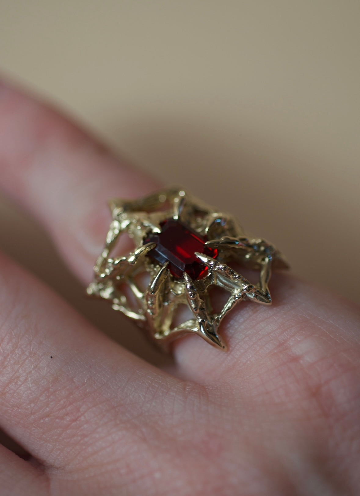 Gothic inspired sculptural gold ring with web structure and red garnet handmade using the lost wax casting technique