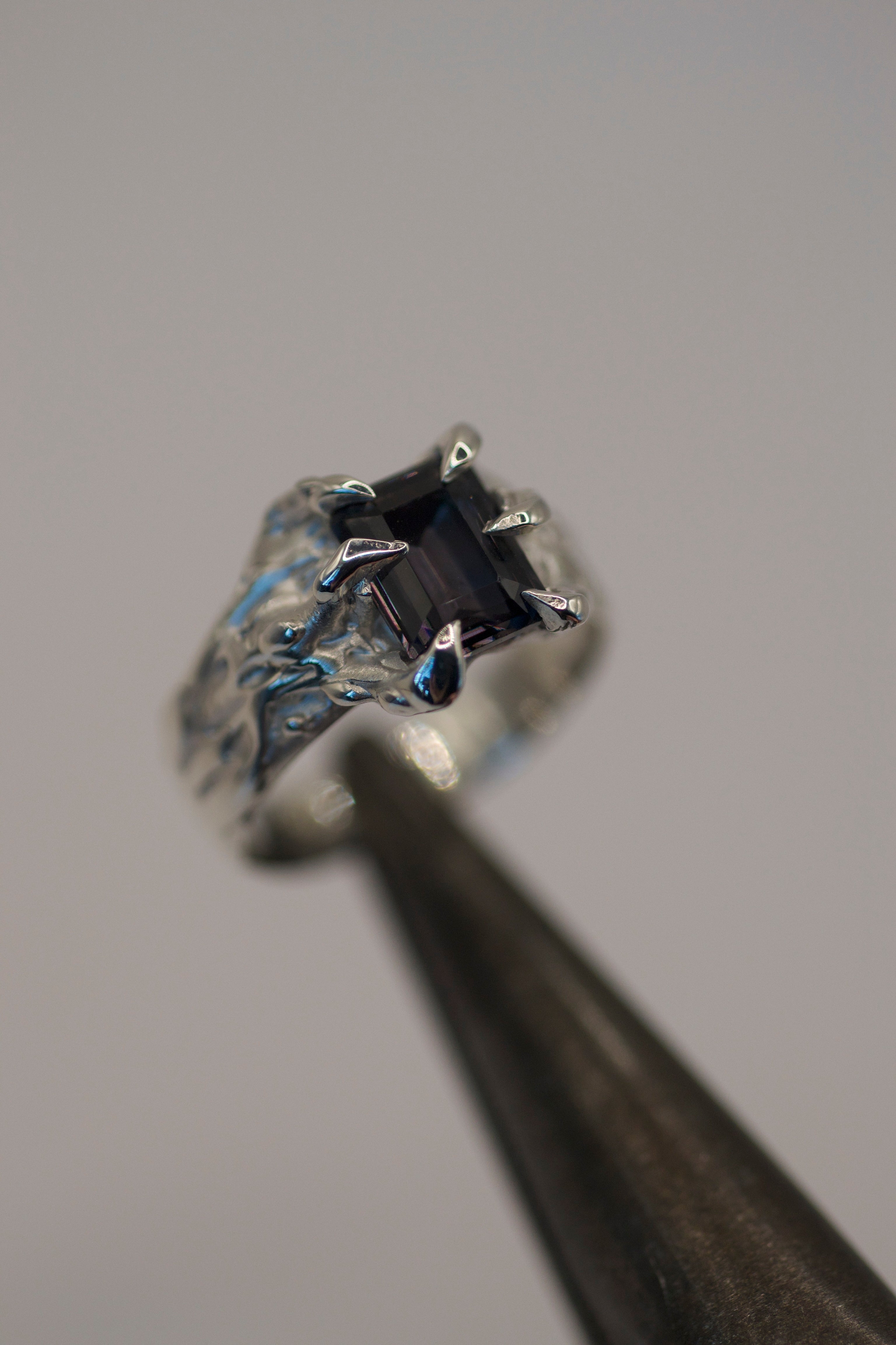 Close up of the Dragon Ring held in tweezers showing organic molten silver claw detail, handmade using the lost wax casting technique
