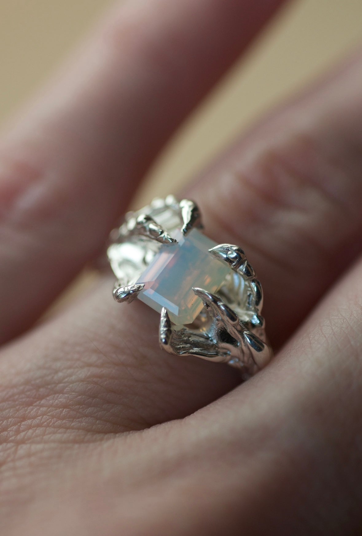 Lost wax cast silver Dragon Ring worn on hand showing organic molten silver claws and lab-grown gemstone handmade alternative ring made using the wax carving technique