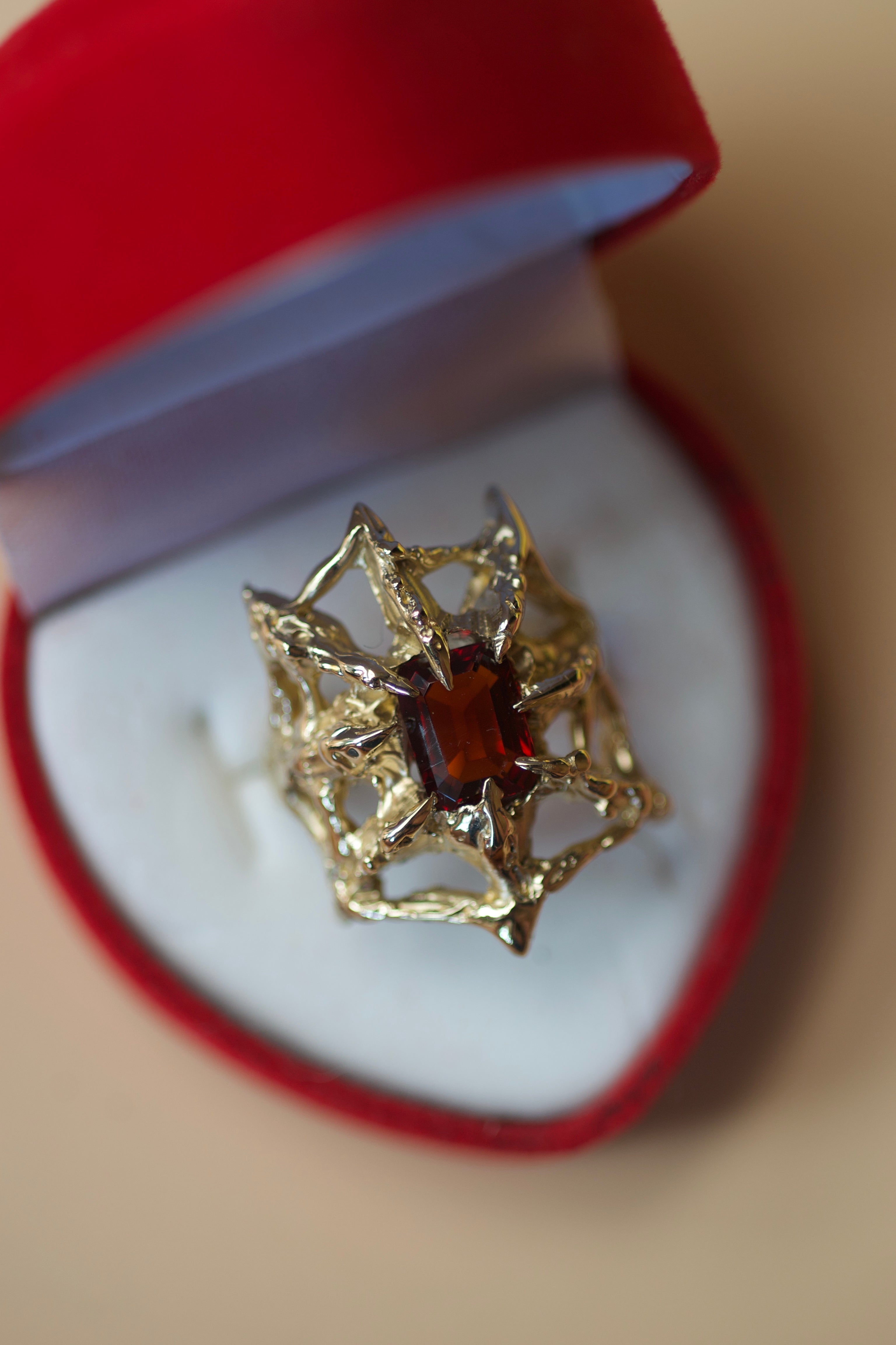 gold spider web ring with emerald cut garner