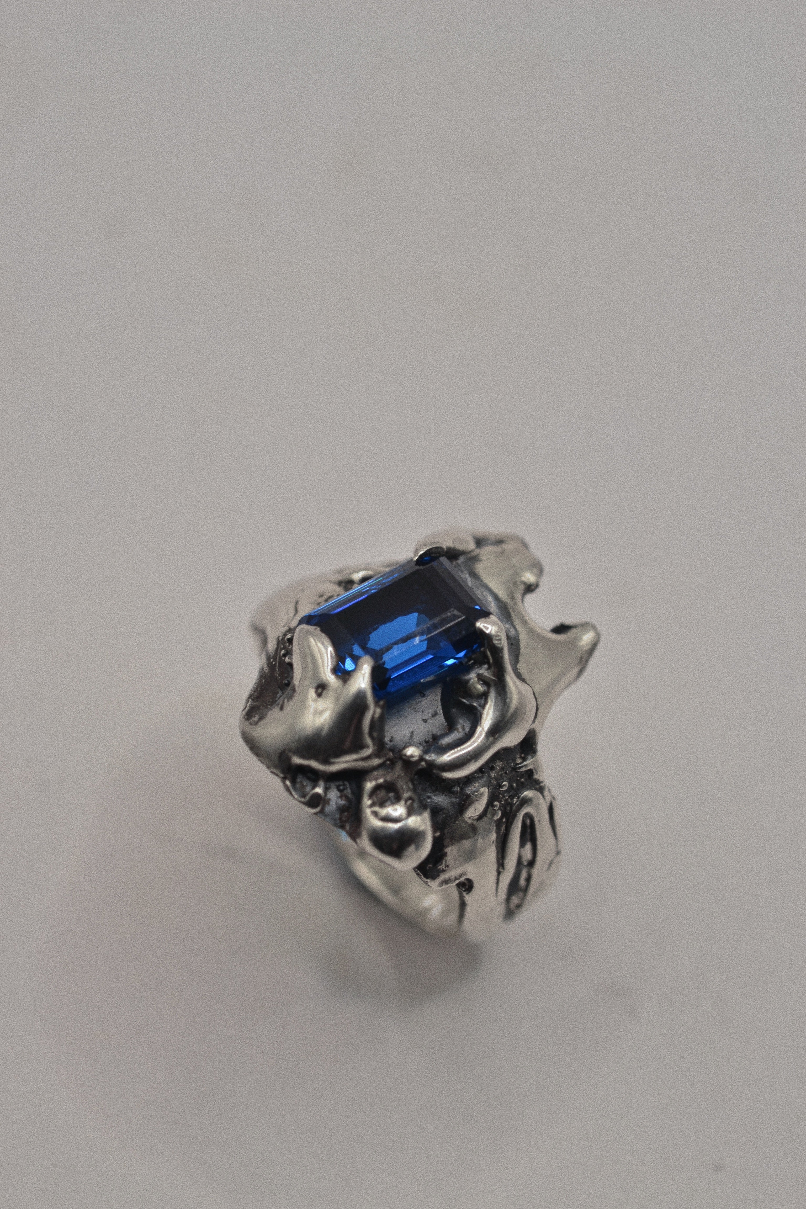 Close up of the Infinity Ring showing extreme dimensional organic sterling silver forms surrounding blue sapphire handmade using the lost wax technique