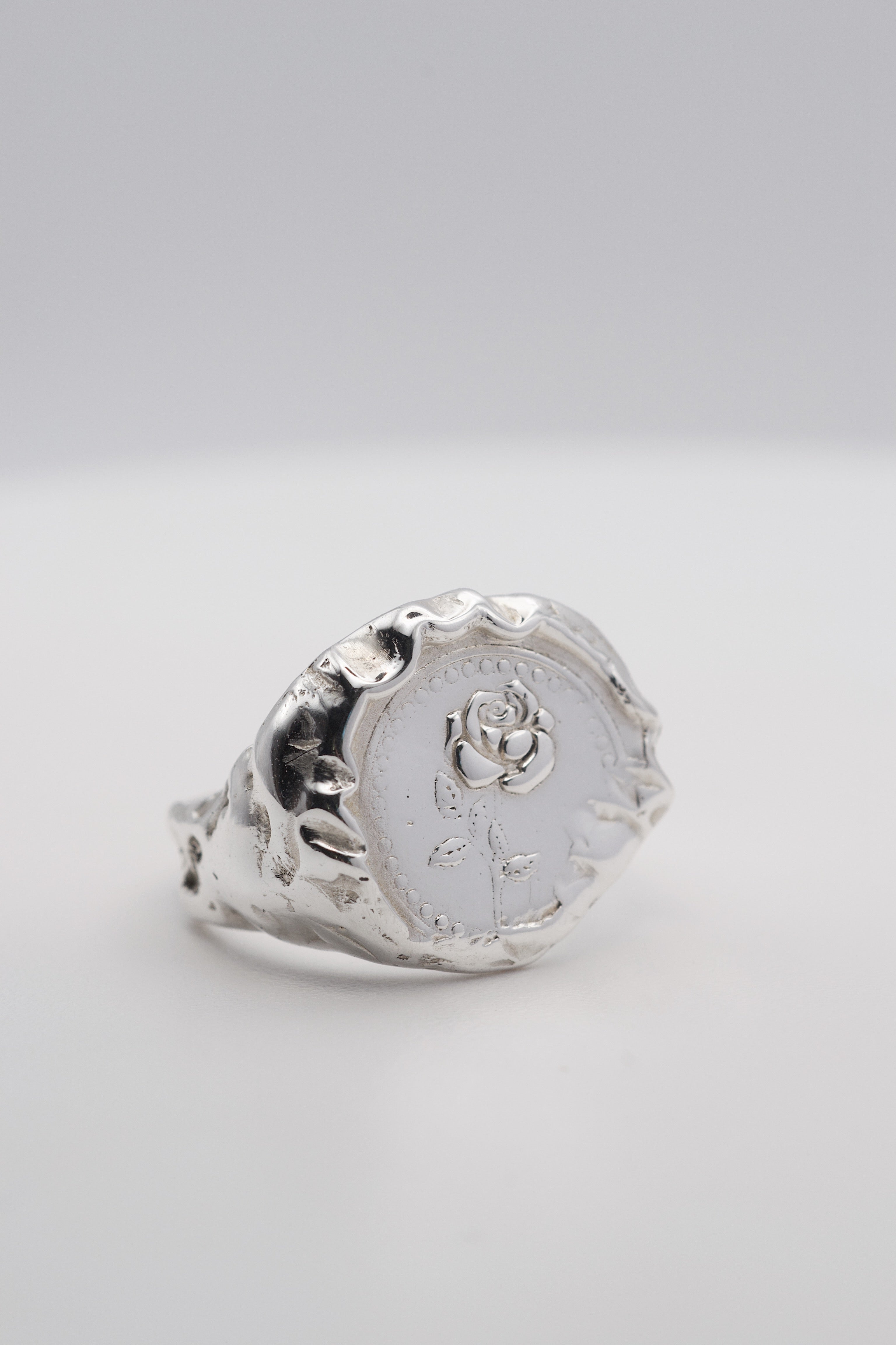 Side angle of the La Vie En Rose Ring showing organic recycled sterling silver signet band with embossed rose detail