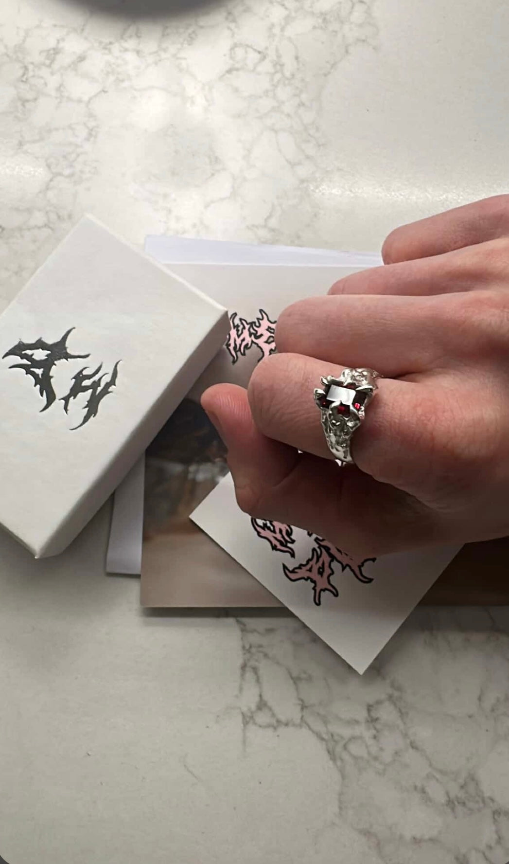 Handmade Metal Bones Jewellery silver rings displayed on branded packaging