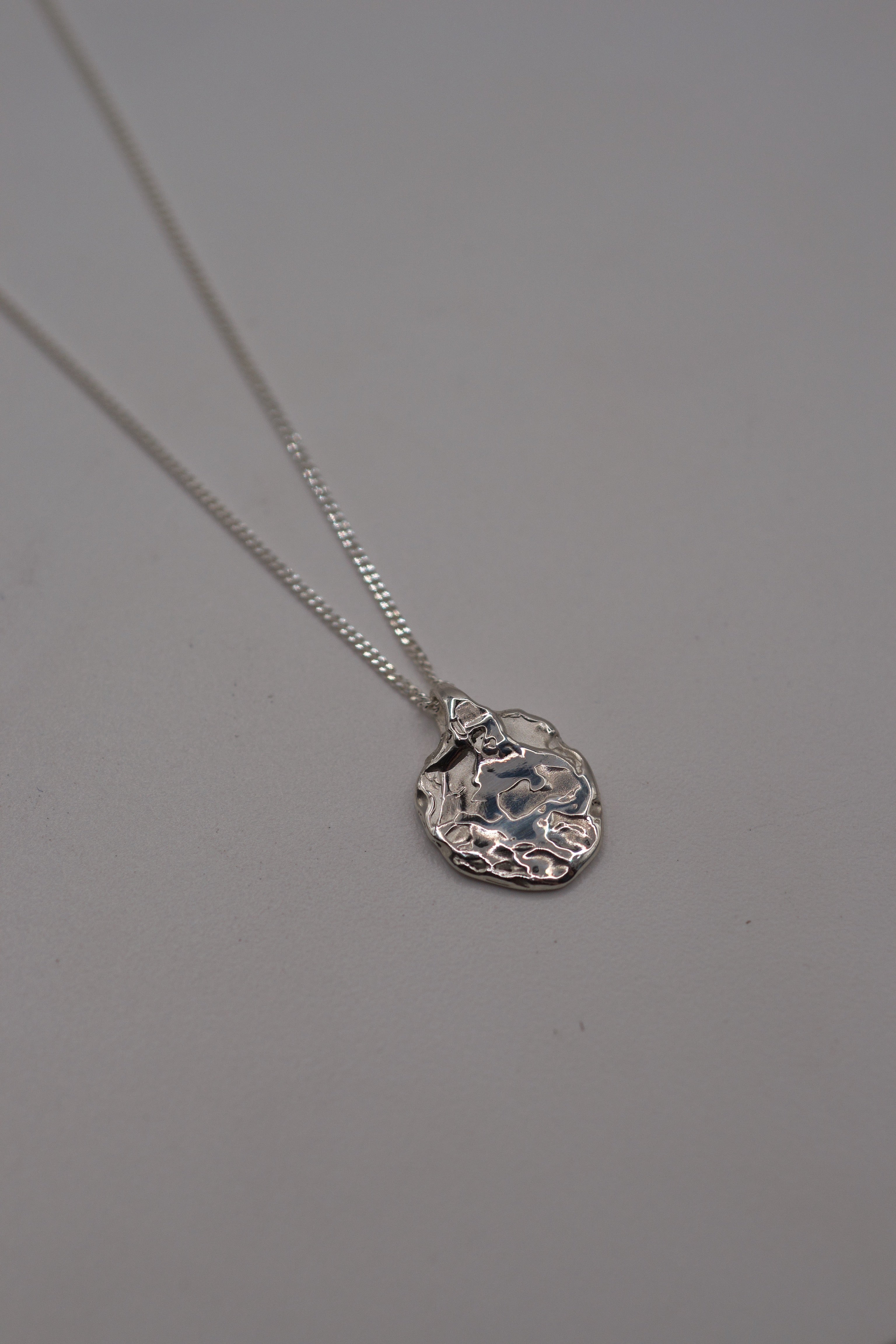 Handmade lost wax cast sterling silver Molten Pendant worn on diamond-cut curb chain organic alternative silver necklace