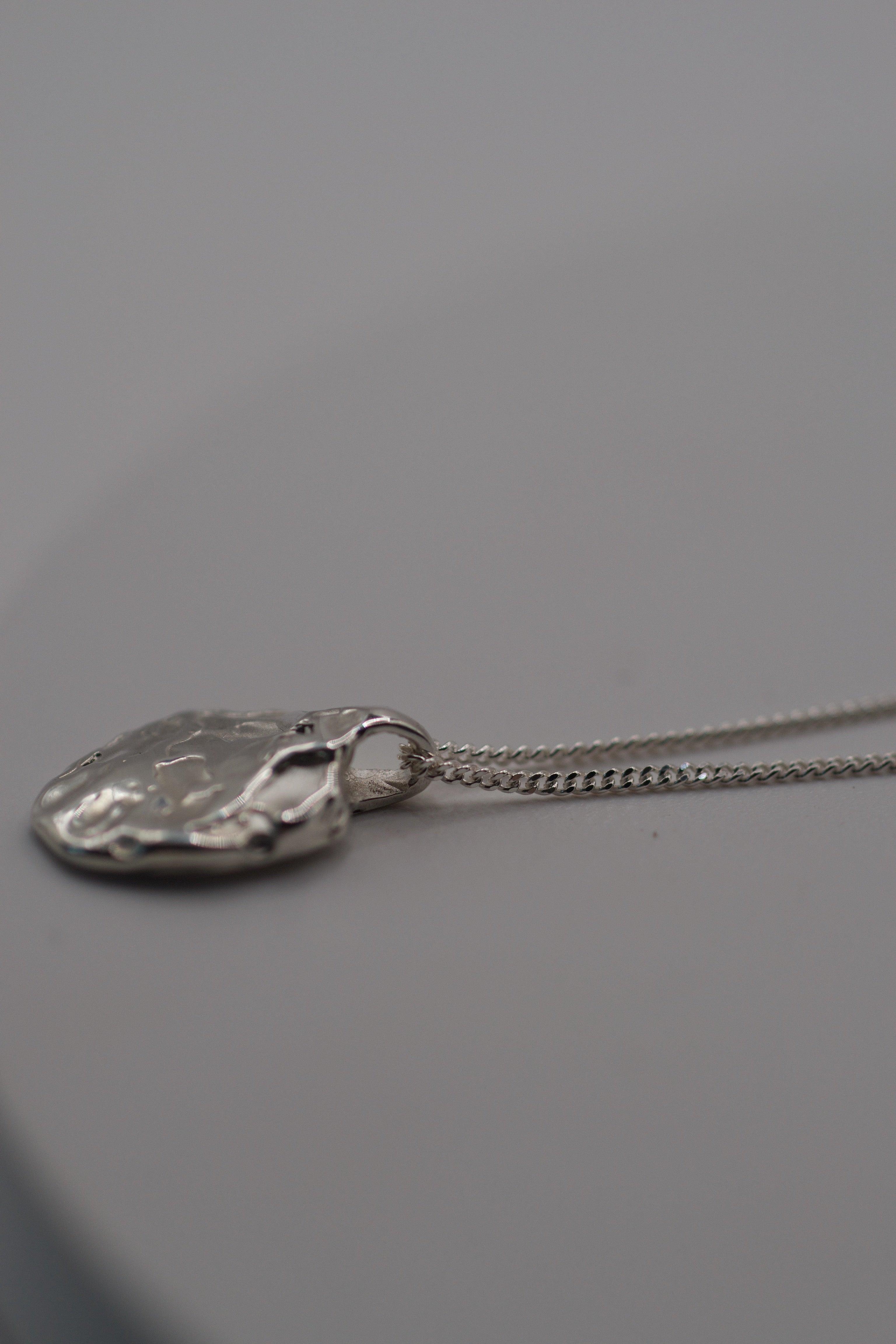Close up detail of the Molten Pendant showing soft organic textured sterling silver form lost wax cast using the wax carving technique