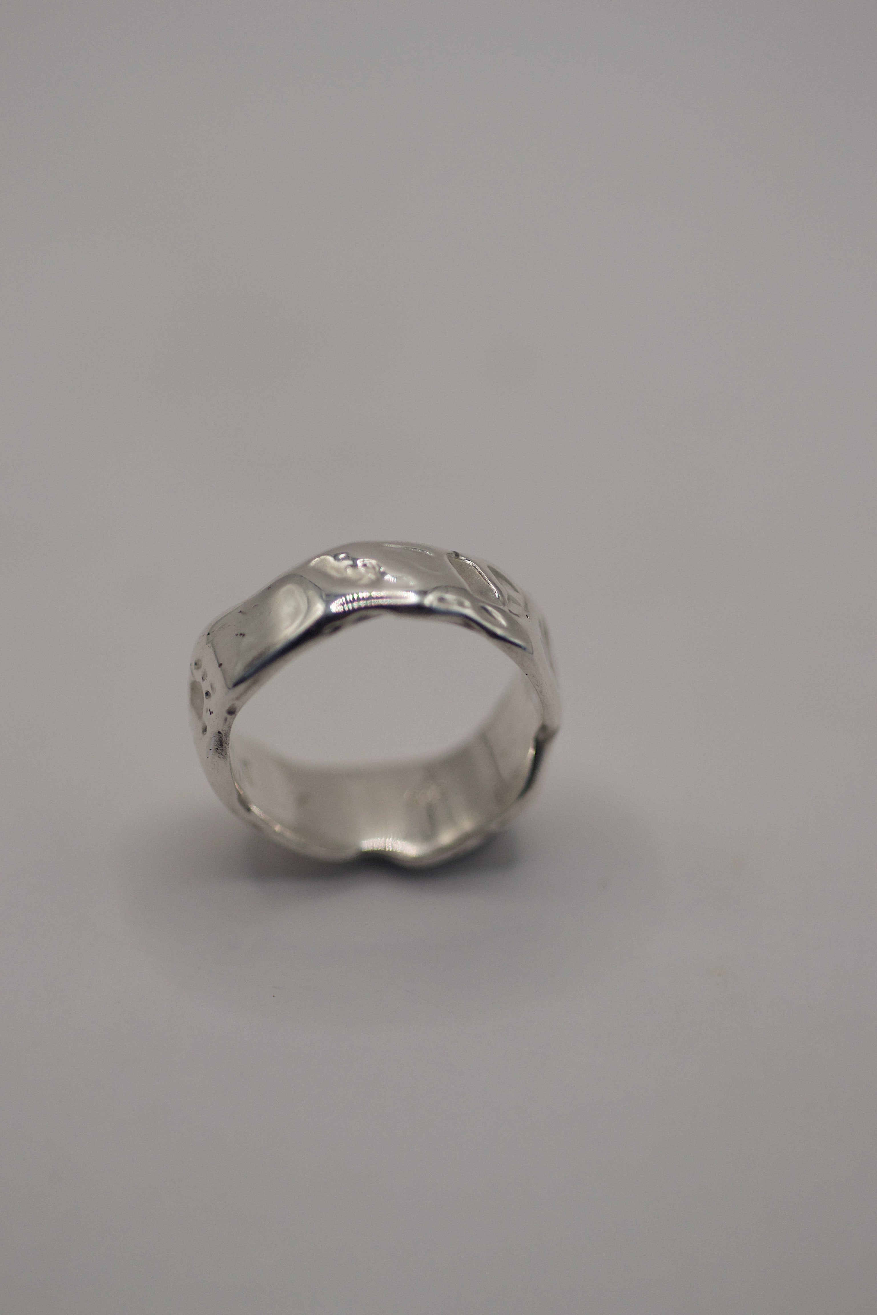 Side angle of the Molten Ring showing organic recycled sterling silver band form handmade using lost wax casting technique