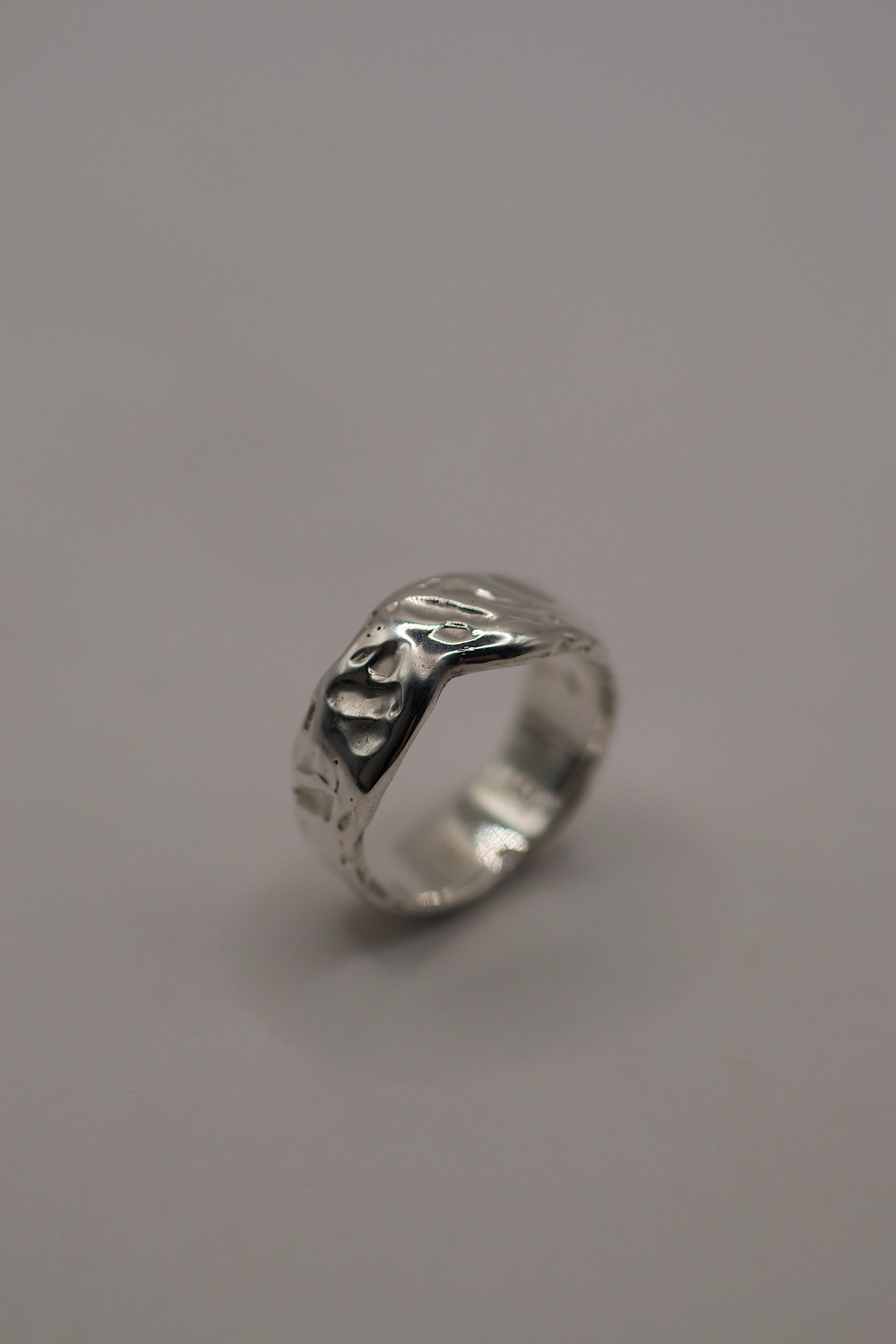 Lost wax cast silver Molten Ring on dark background showing organic flowing sterling silver band with molten texture alternative jewellery