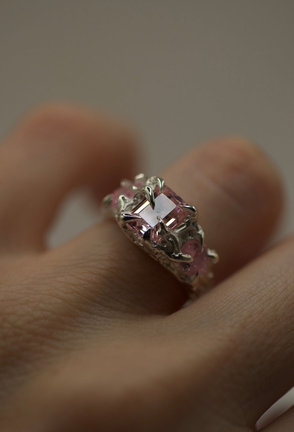 Hand-sculpted silver claw ring with pink emerald-cut and heart stones, molten organic design, alternative handmade jewellery for gothic and bold style on hand
