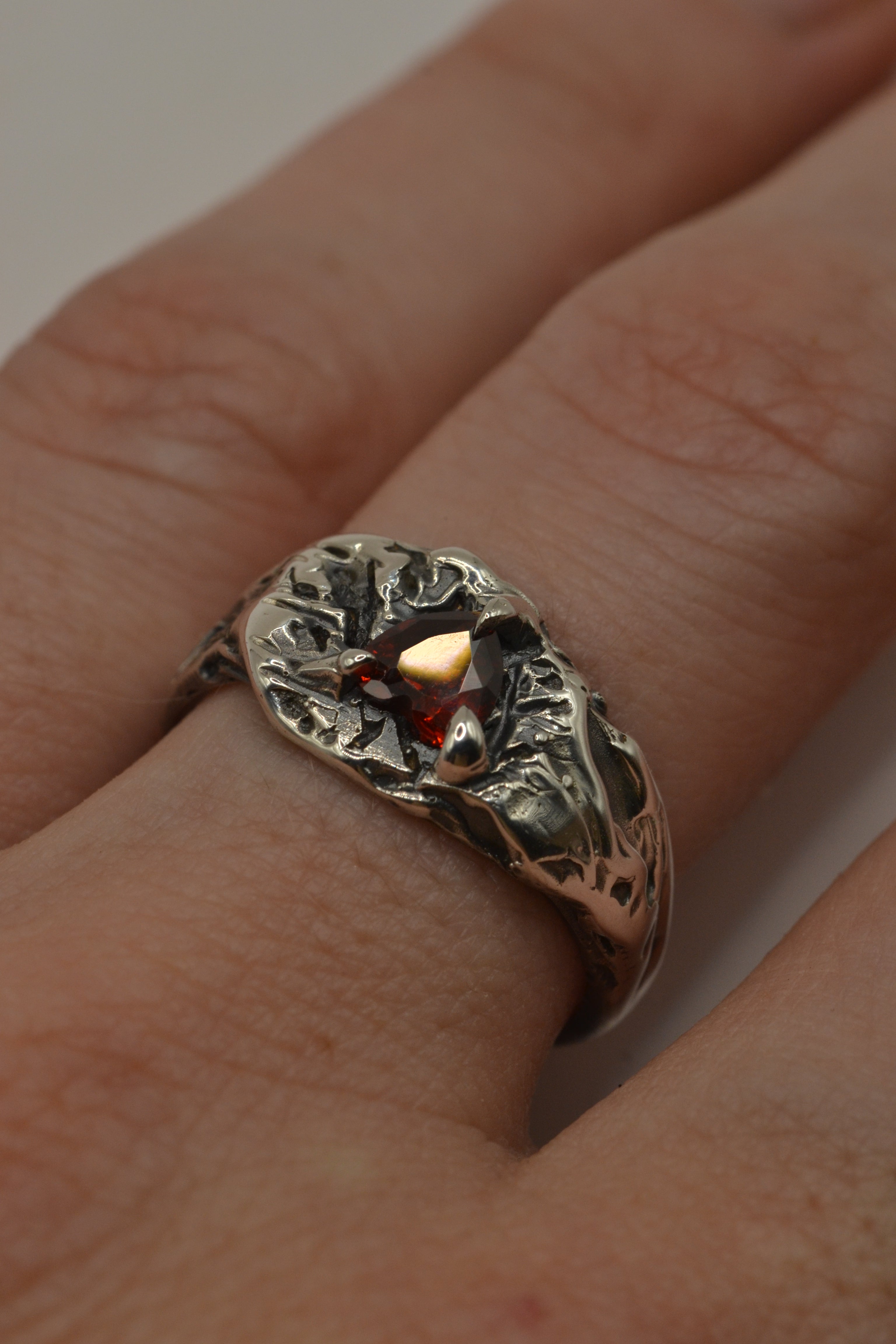 organic sterling silver ring with a heart shape garnet stone in the centre. hand carved using the lost wax method. 
