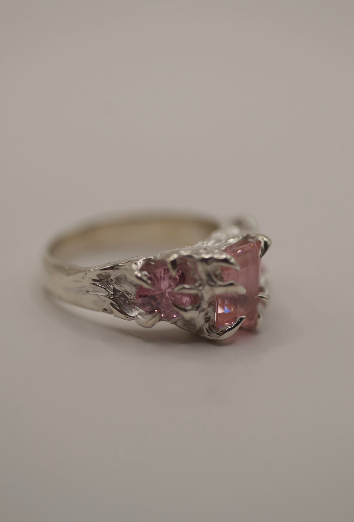 Hand-sculpted silver claw ring with pink emerald-cut and heart stones, molten organic design, alternative handmade jewellery for gothic and bold style side