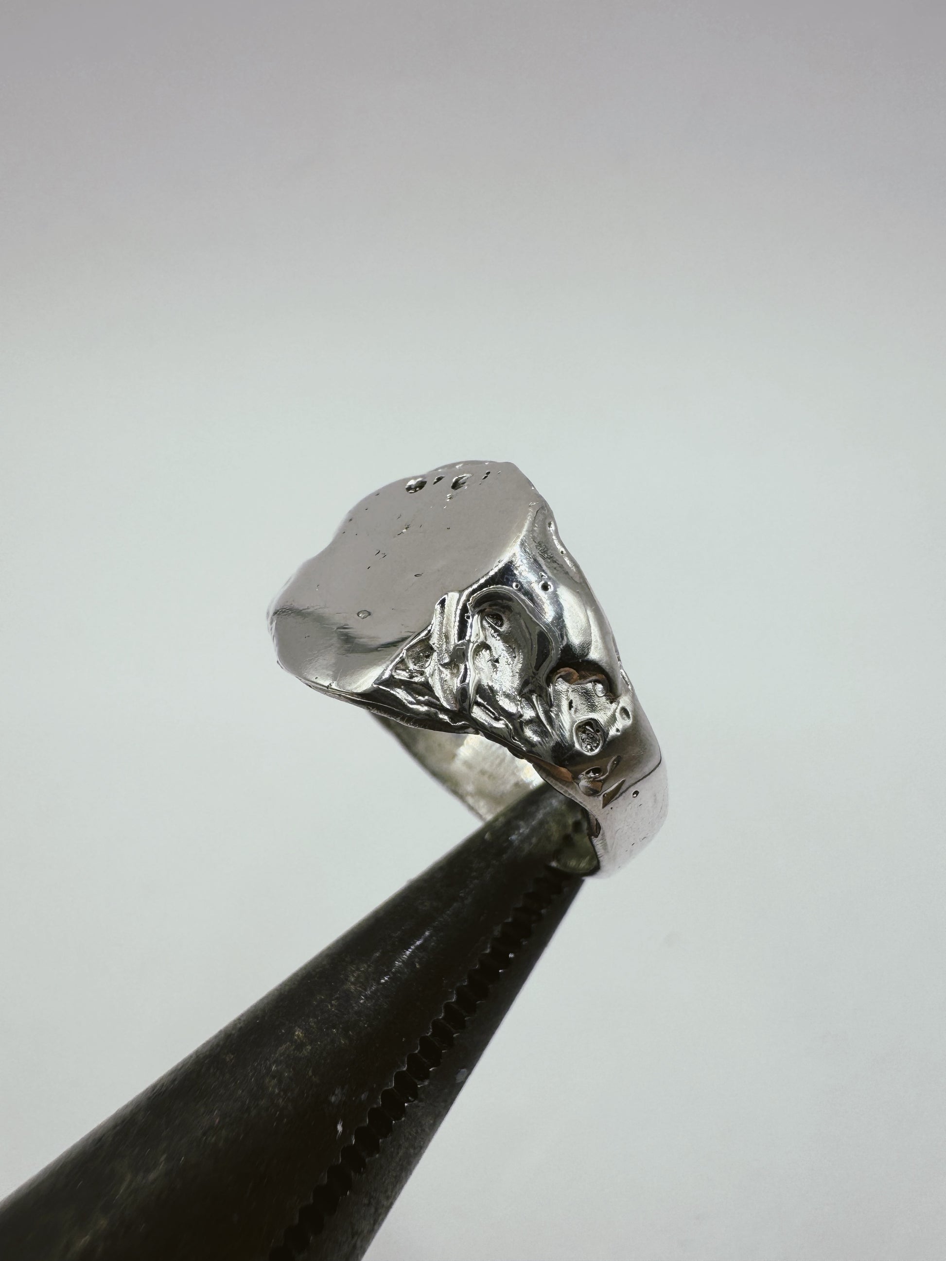 Stunning organic handmade signet ring with textured band and a flat smooth surface created using the lost wax method