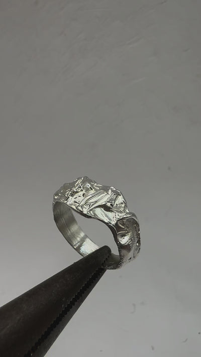 925 sterling silver band with an abstract, drippy design. The surface appears fluid and molten, with smooth contours interrupted by natural inclusions and irregular indentations, making each piece unique video.