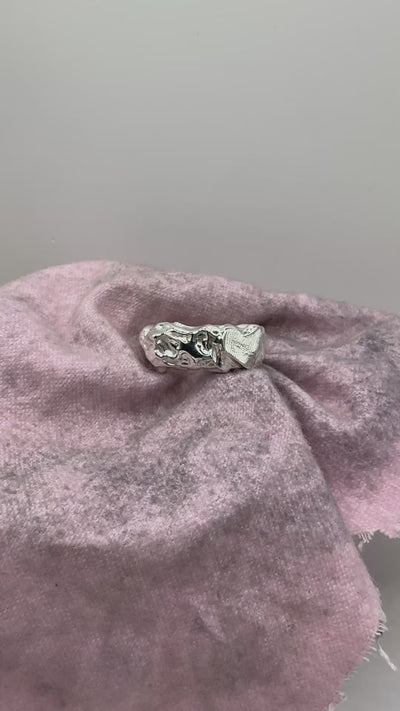 Organic handmade sterling silver ring with texture and fingerprint impression on surface