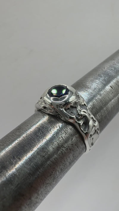 Handmade gothic silver ring with deep blue sapphire, shown worn on finger. Organic texture and dark patina give a moody, alternative look.