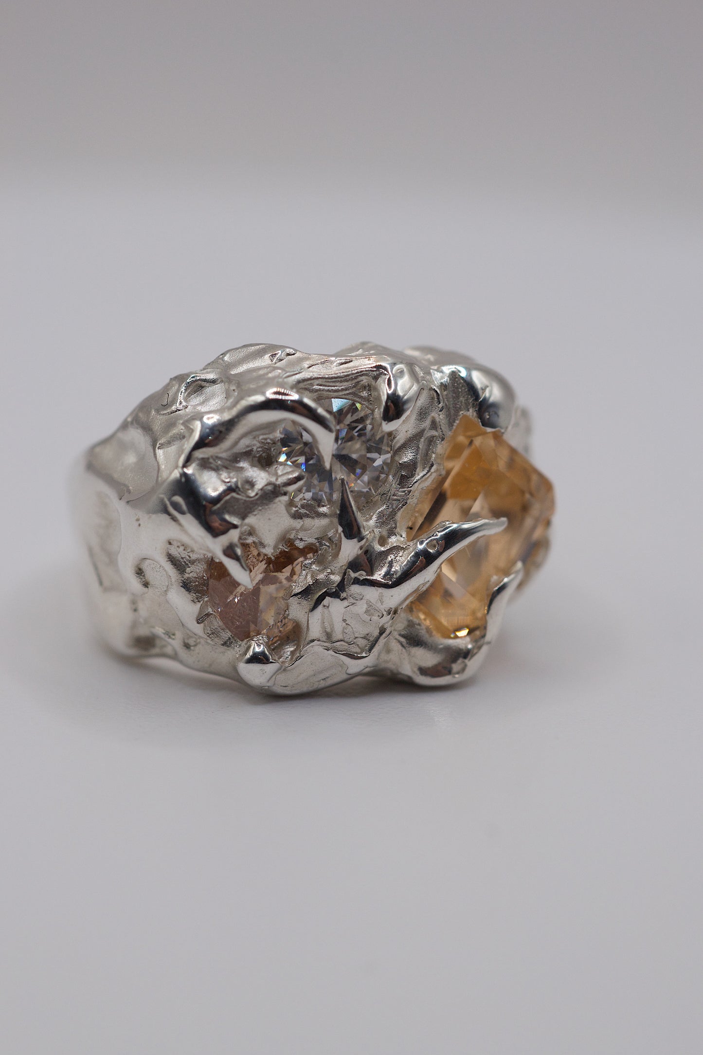 Silver ring with a textured design on a light gray background