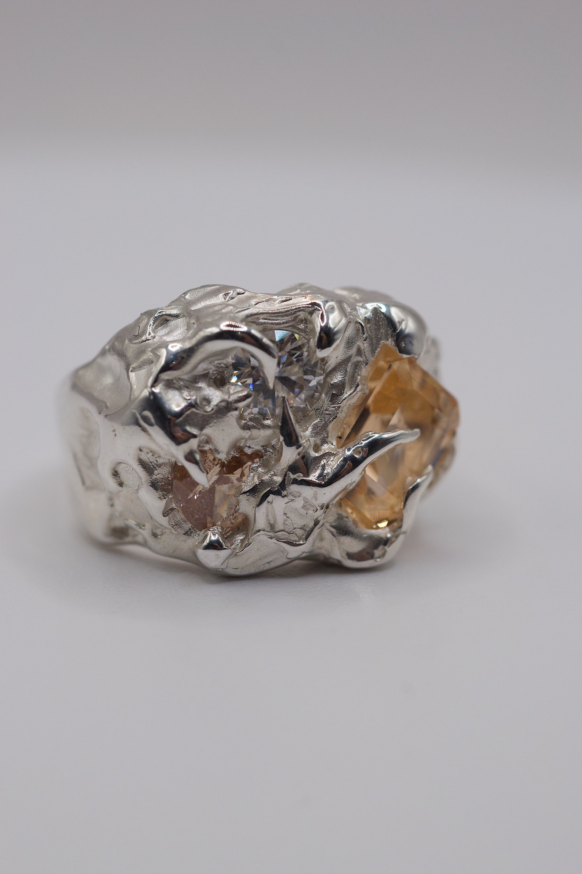 Silver ring with a textured design on a light gray background