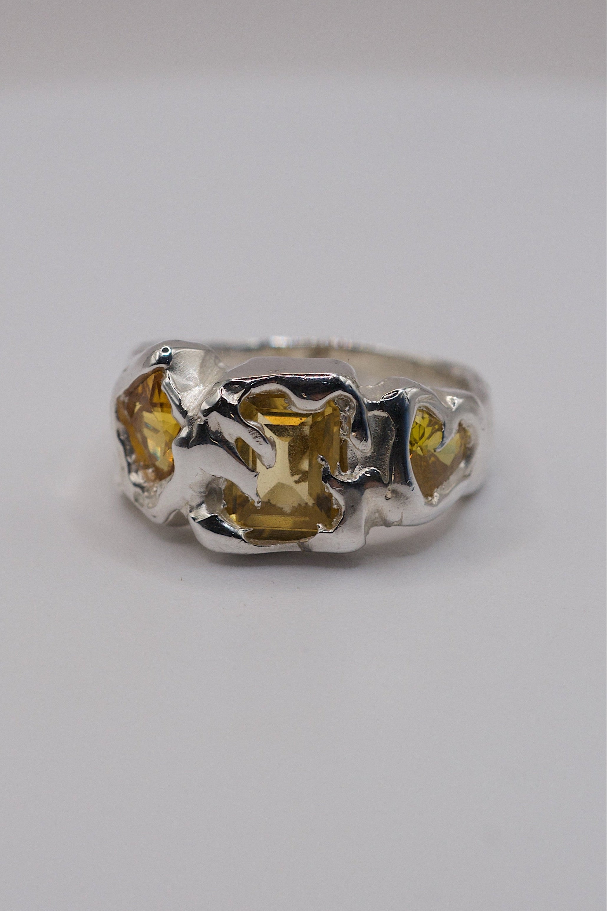 Sterling silver ring with yellow gemstones and flowing molten silver.