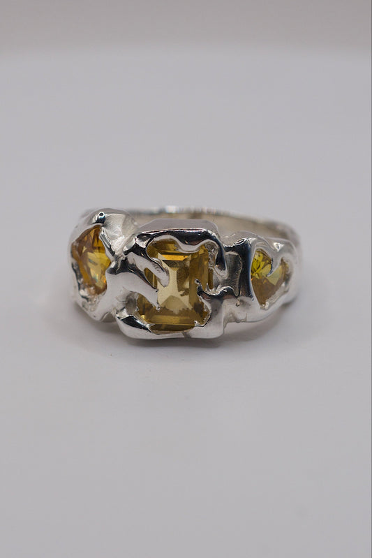 Sterling silver ring with yellow gemstones and flowing molten silver.
