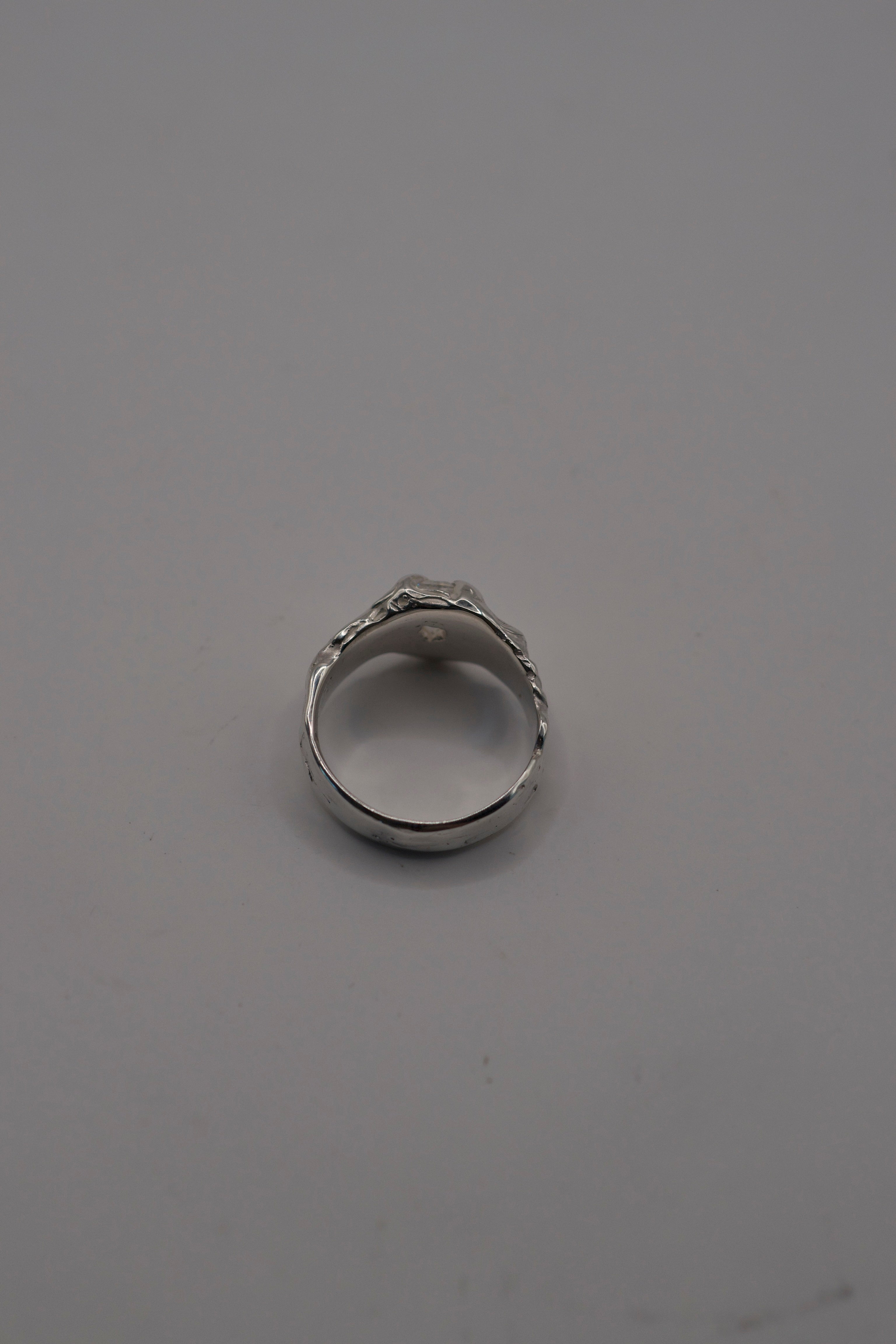 Flat lay of the lost wax cast silver Til Death Ring with kite cut moissanite and deeply textured organic sterling silver band