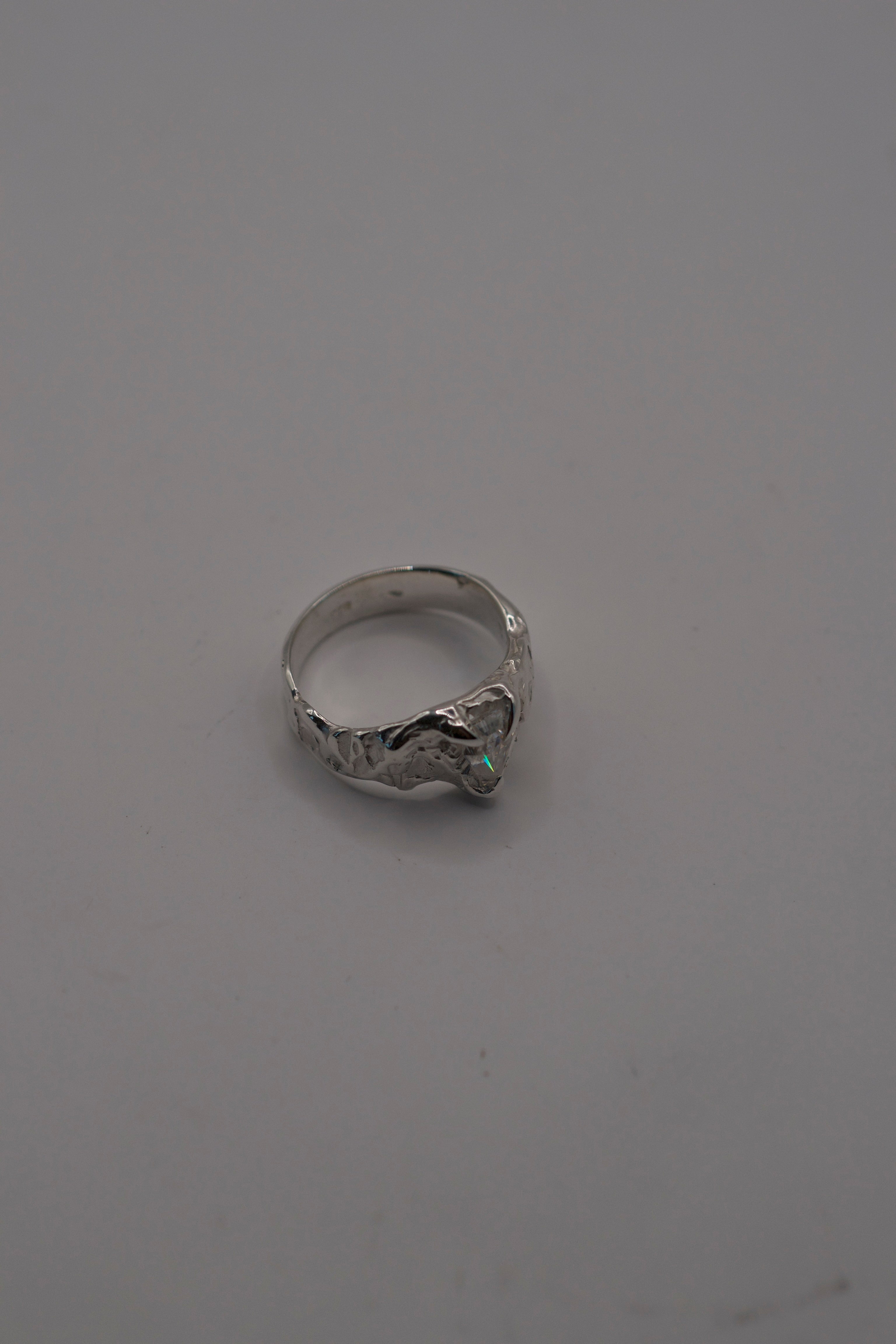 Side angle of the Til Death Ring showing organic textured recycled sterling silver band and kite cut moissanite alternative engagement ring