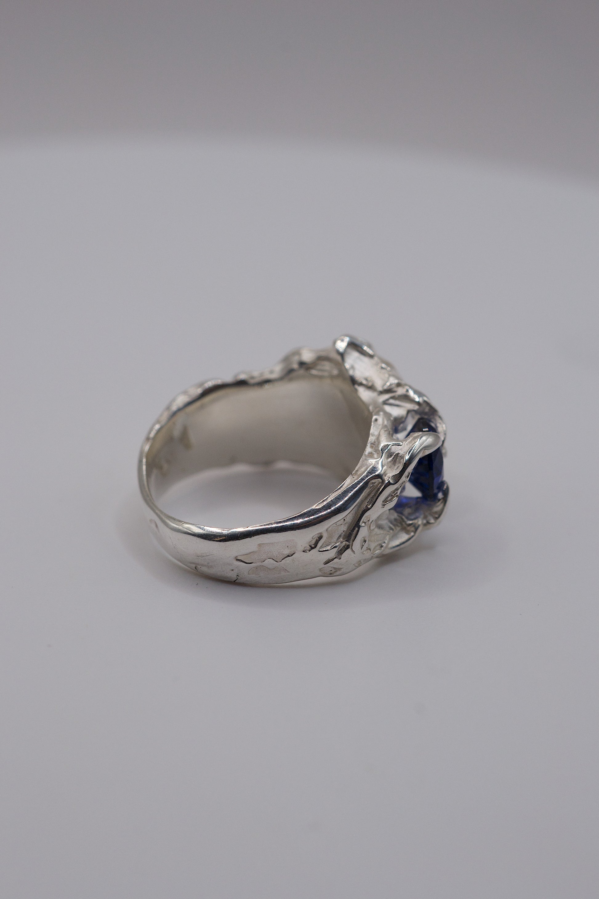 Top view of organic sterling silver ring with sapphire and moissanite with a textured band.