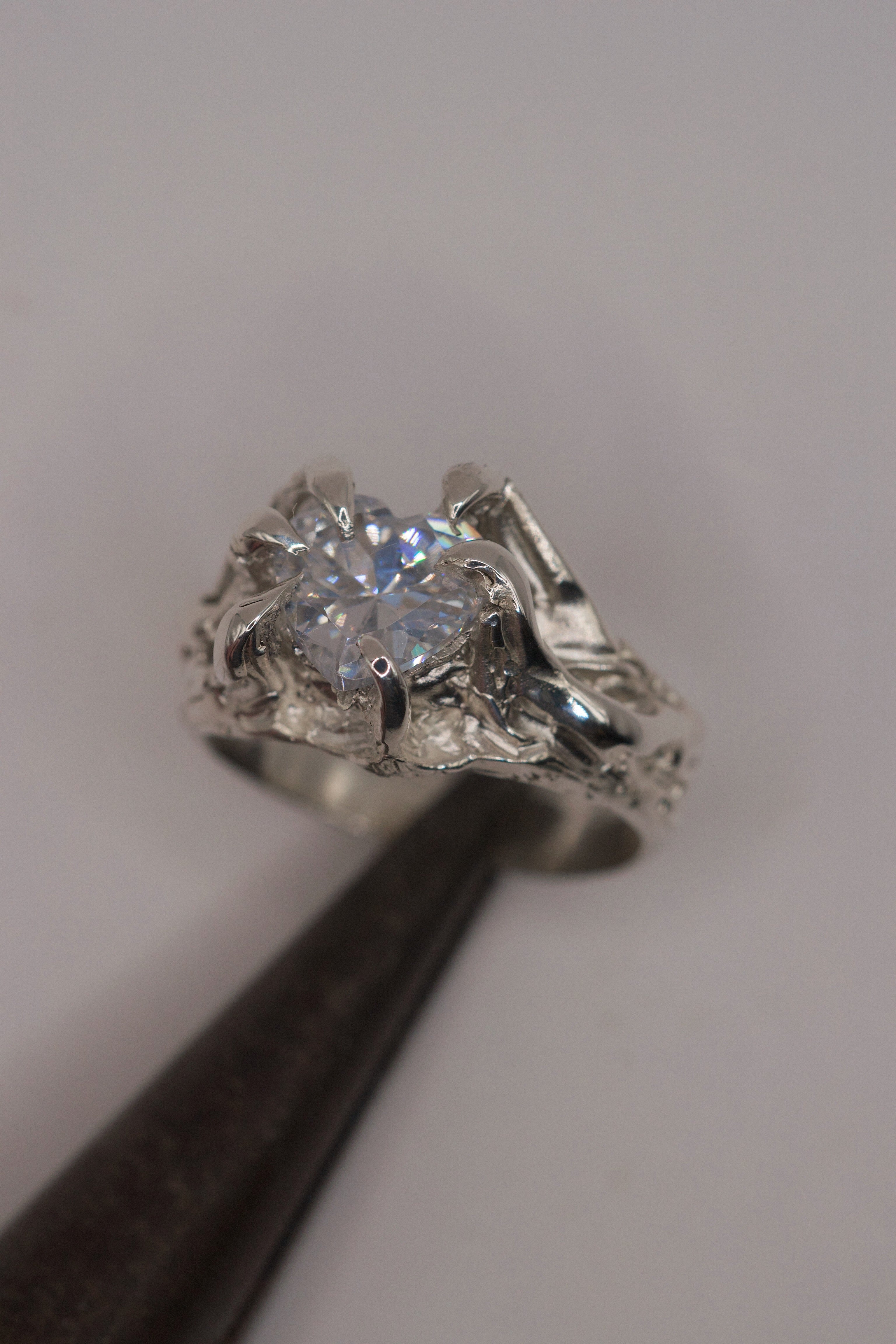 Lost wax cast silver Valentine Ring worn on hand with large heart cubic zirconia and organic molten silver claw setting romantic alternative engagement ring
