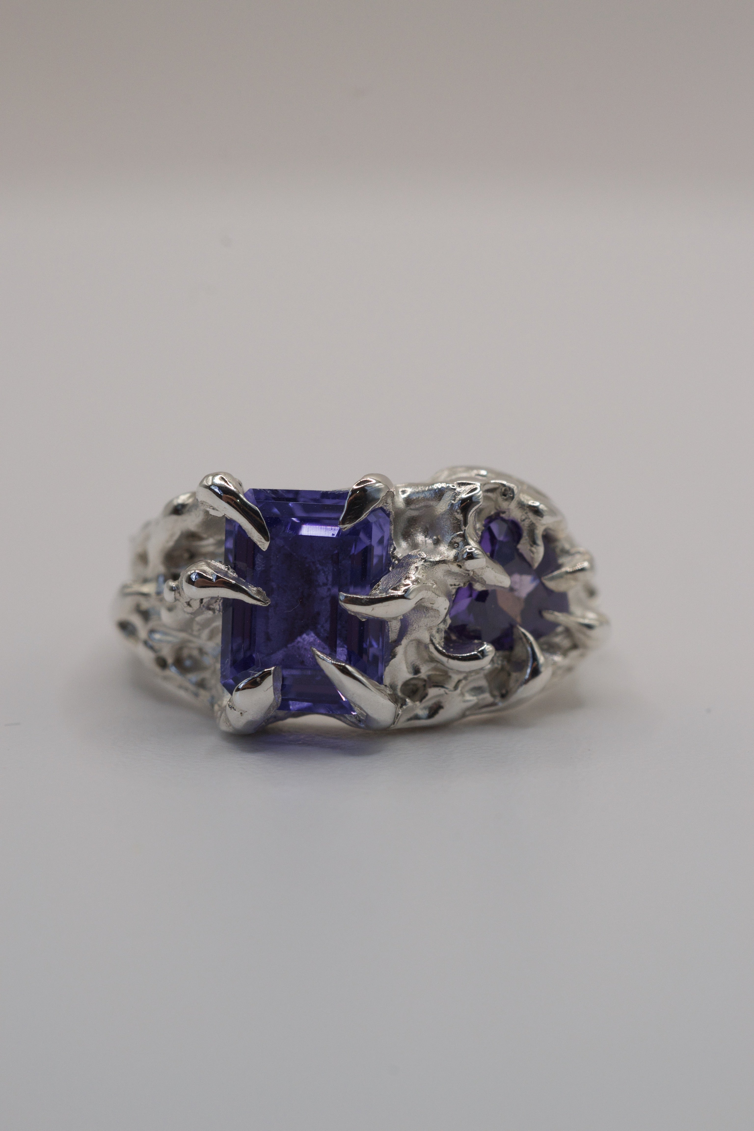Side angle of the Wilted Ring showing organic recycled sterling silver band with gothic claw and purple gemstone detail