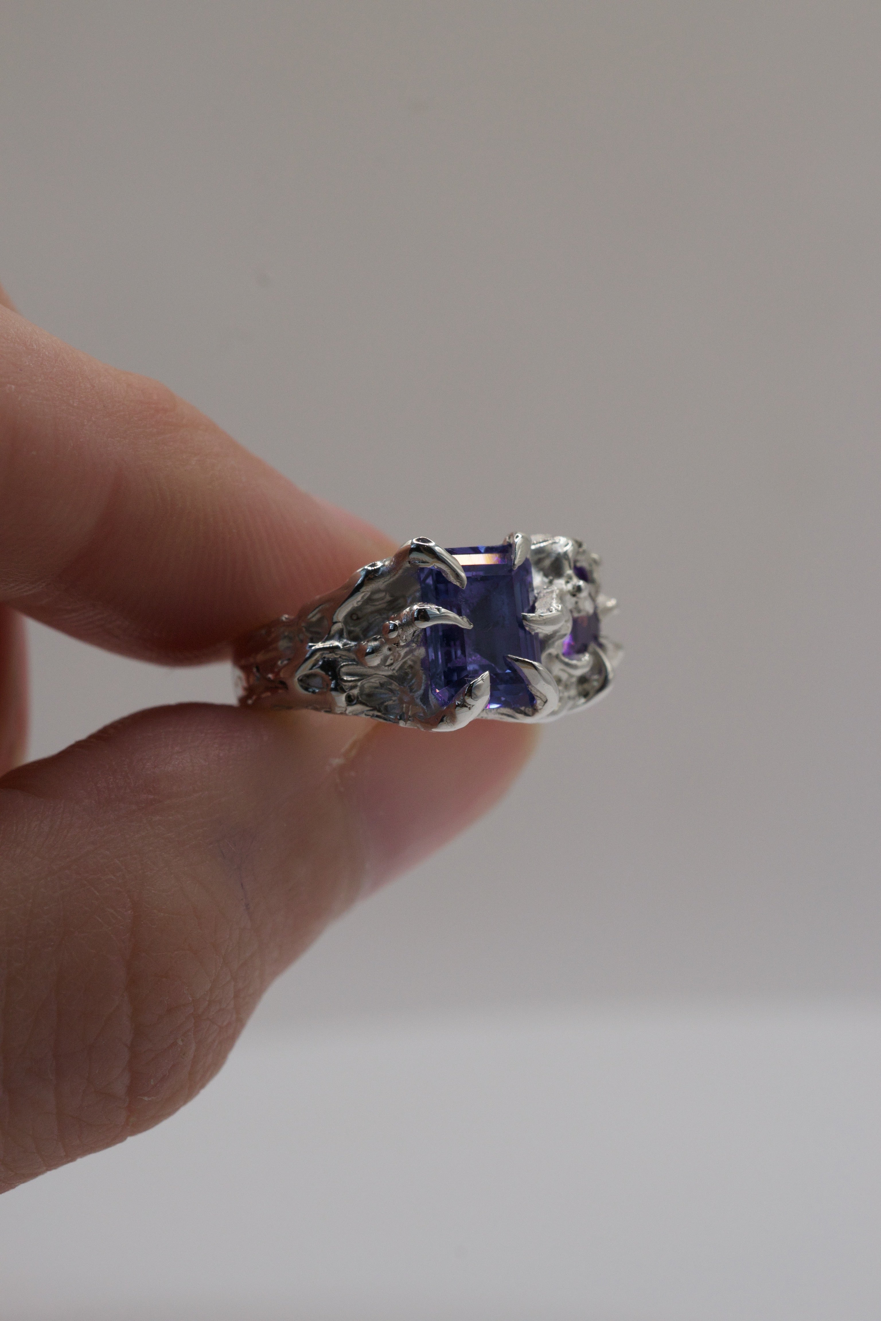 Front view of the Wilted Ring showing purple lab-grown tourmaline and heart cubic zirconia within sharp gothic sterling silver claws handmade using the lost wax technique