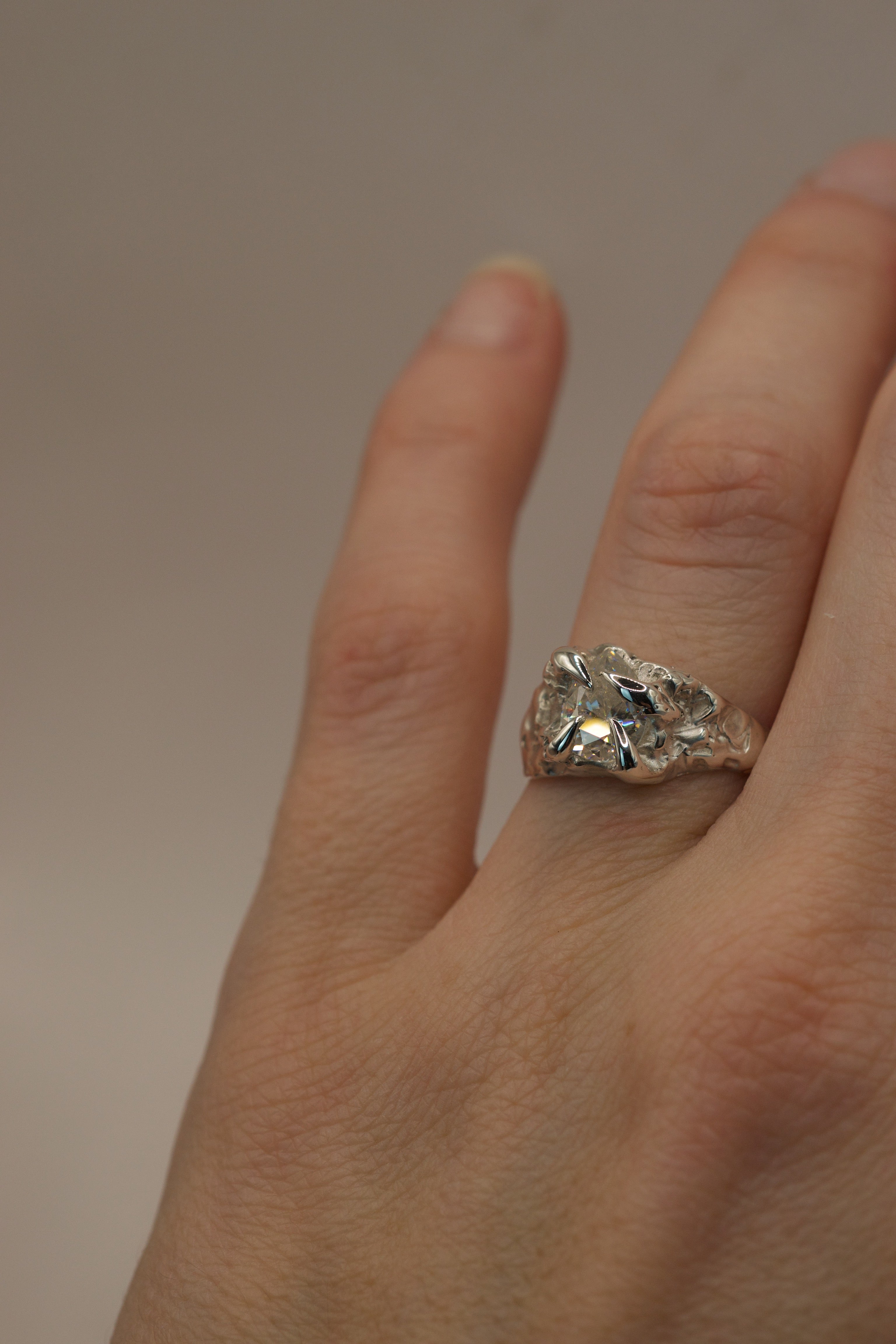 Lost wax cast silver Winter Ring worn on hand sculptural alternative engagement ring with pear cut moissanite and icy organic silver setting